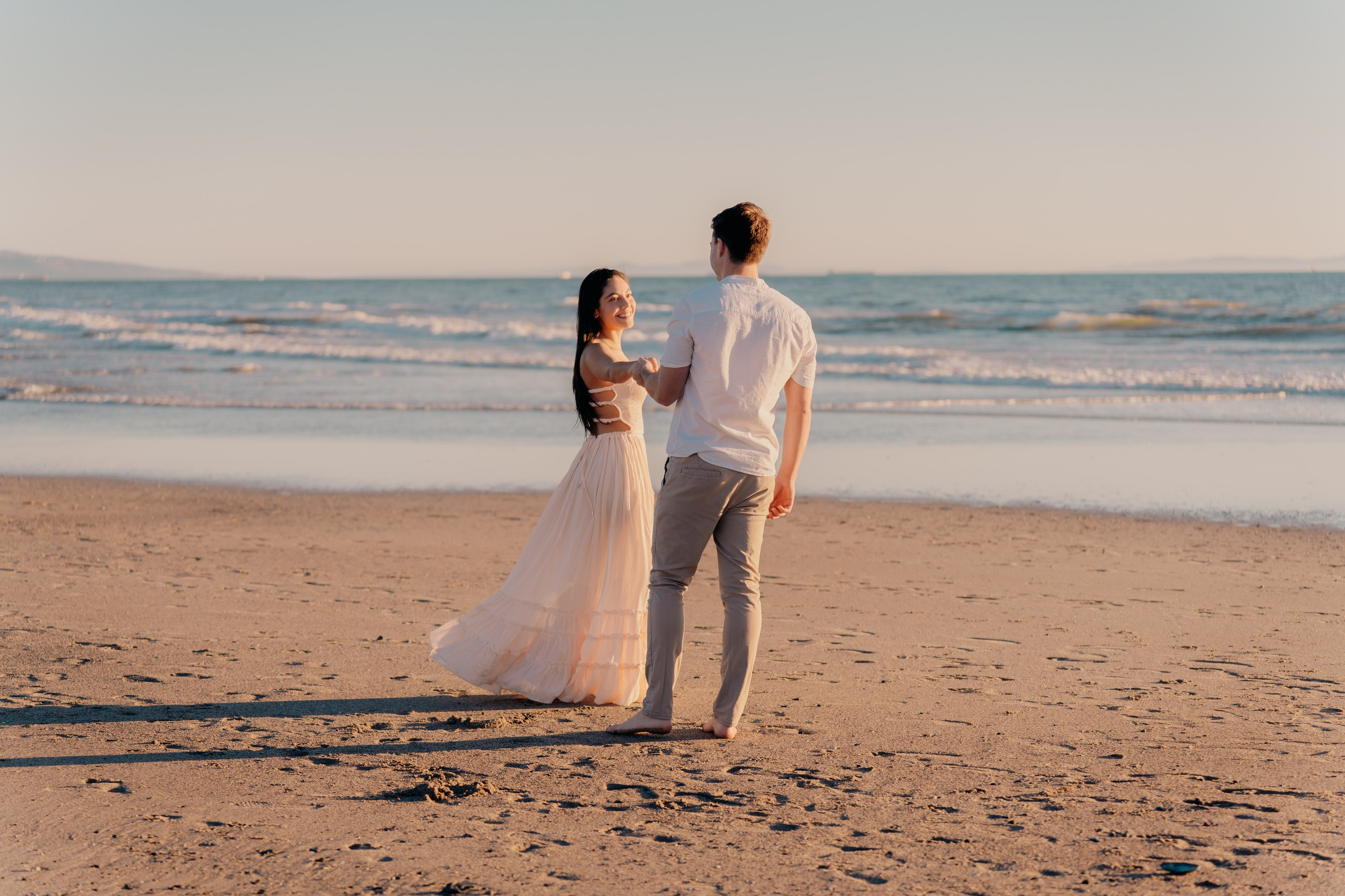 Romantic beach engagement shoot with natural light and ocean backdrop