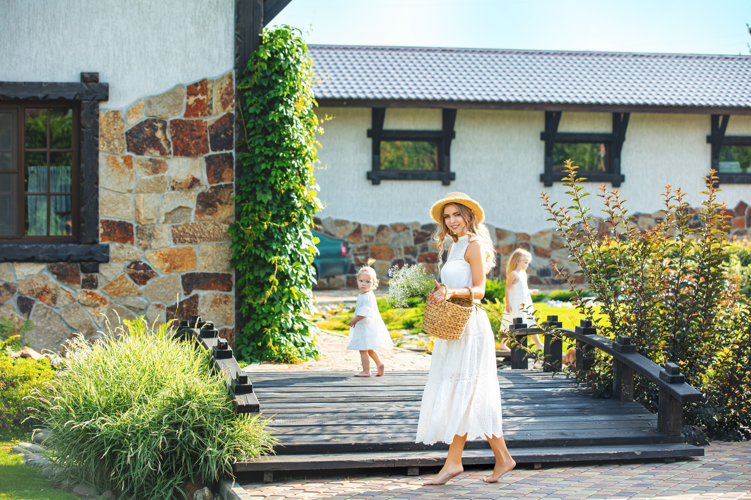 Maman et enfants devant une maison de campagne, instant tendre capturé en séance photo familiale