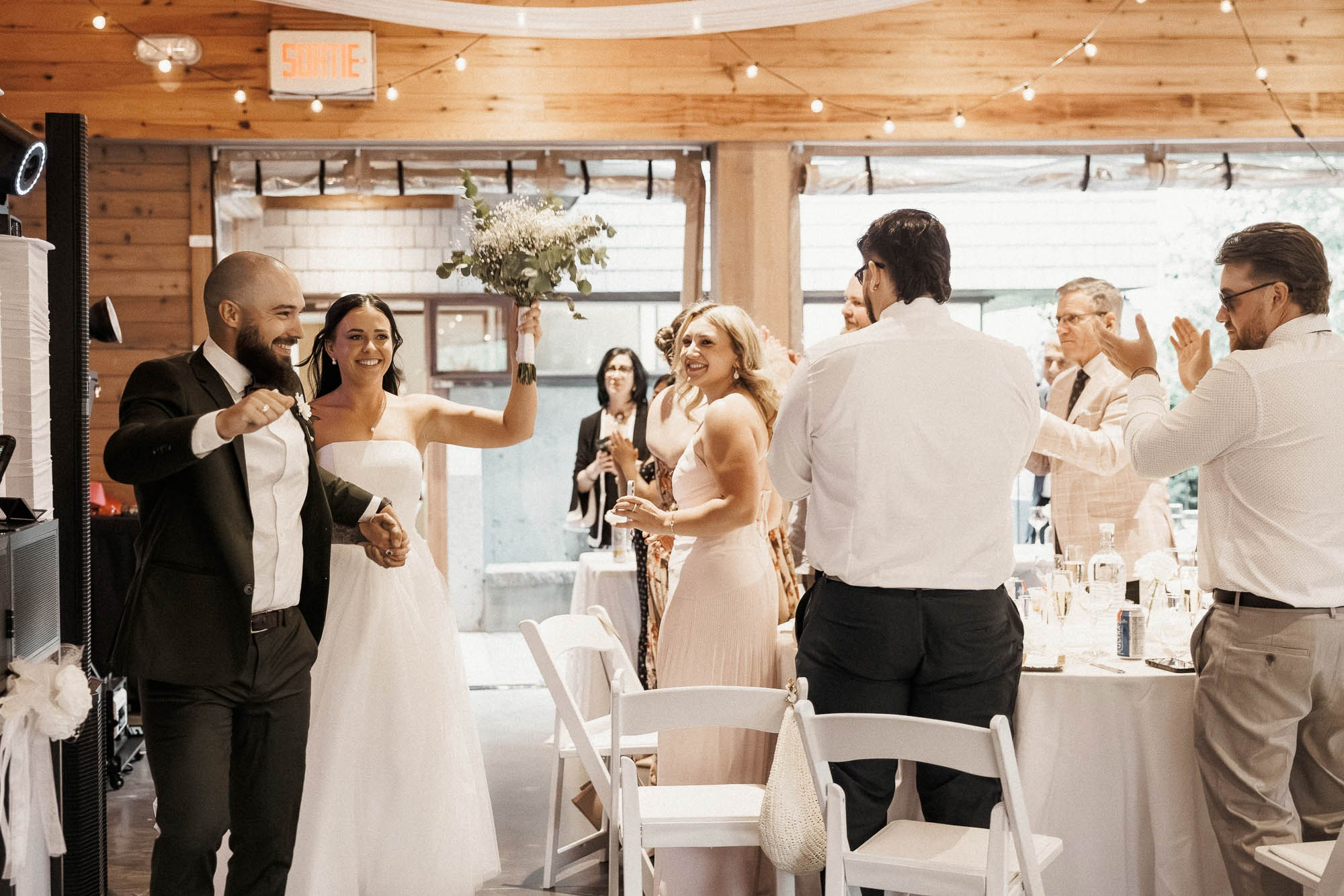 Kendyl et Mikey sourient et lèvent les bras pendant que les invités les accueillent.