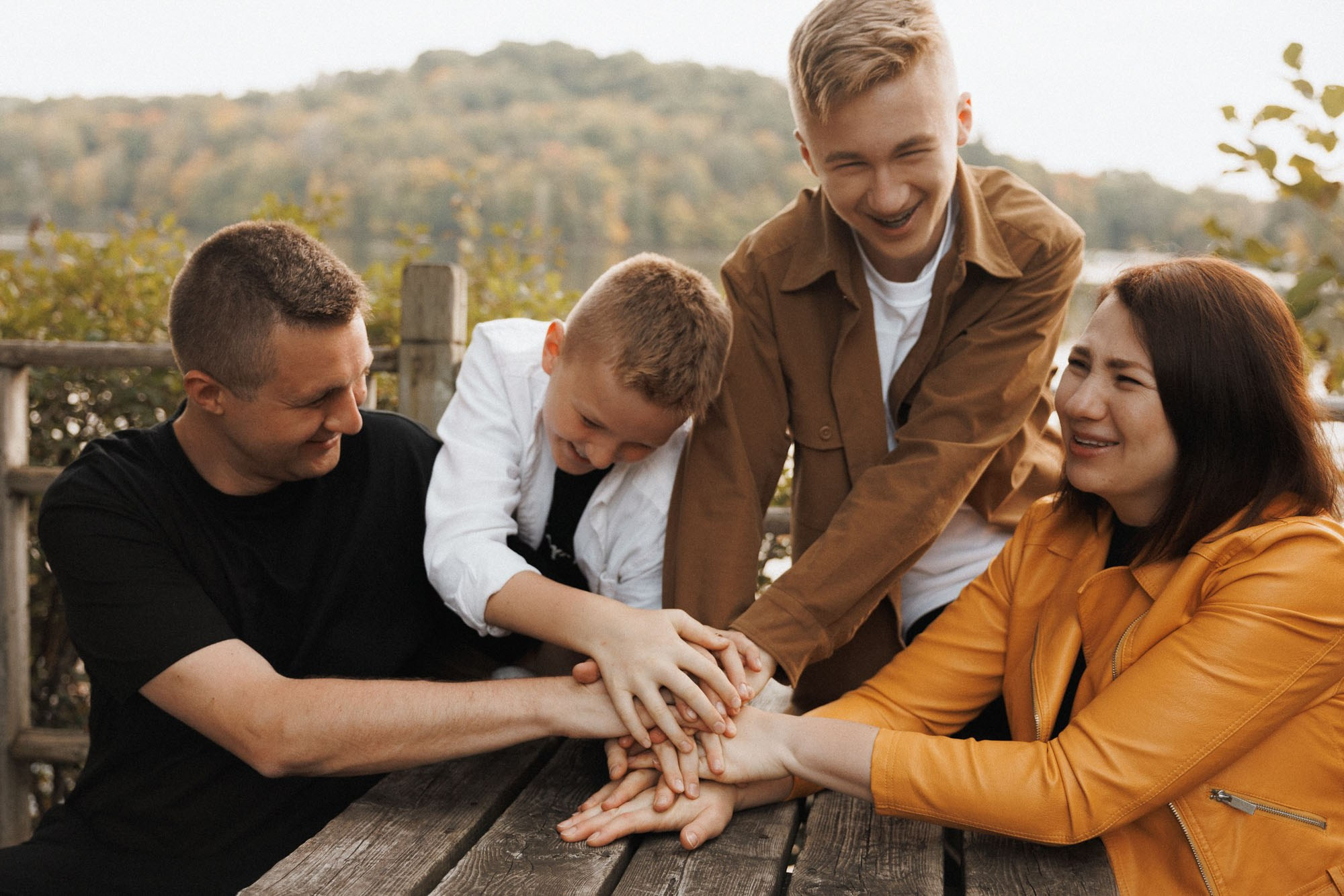 Family of four gathered around a picnic table in autumn