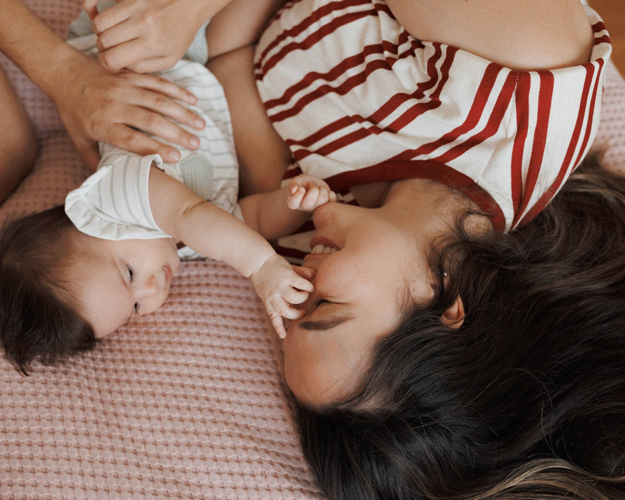 Mother lying face-to-face with her baby during an at-home session
