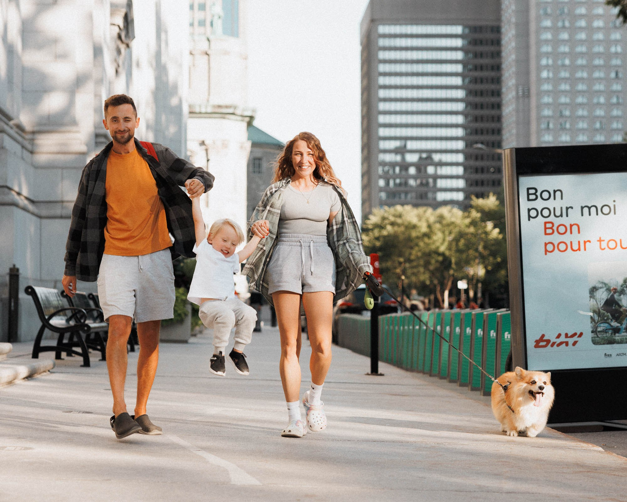 Parents walking through downtown Montreal with their toddler and dog