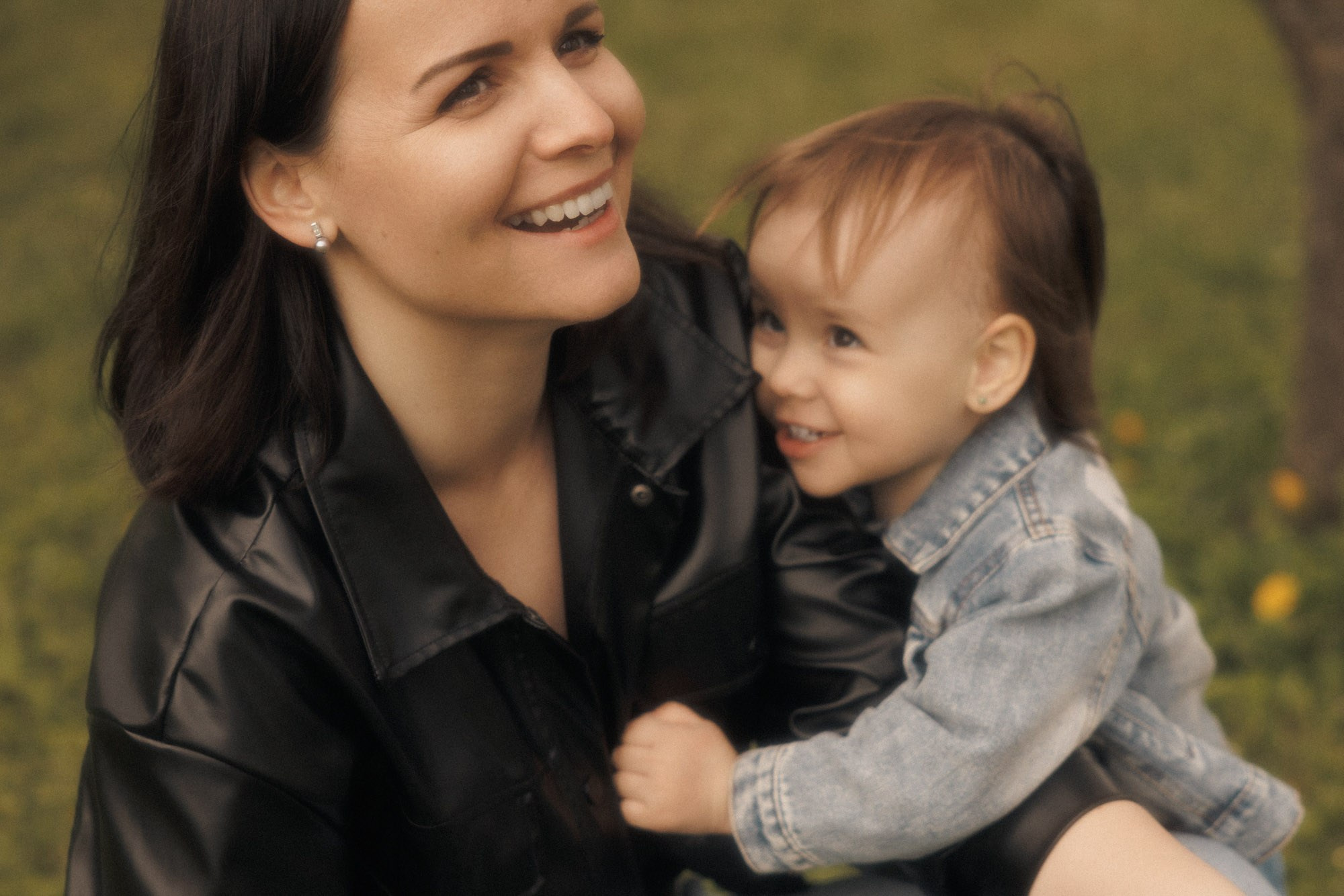 Mother laughing with her young child during an outdoor family session