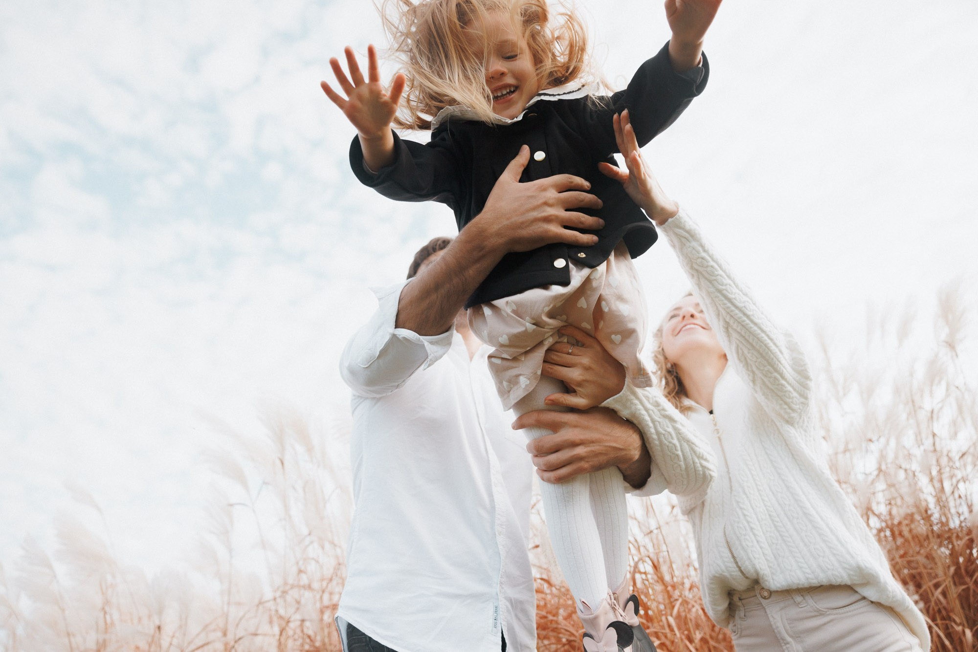 Father lifting his young child into the air during a playful family session