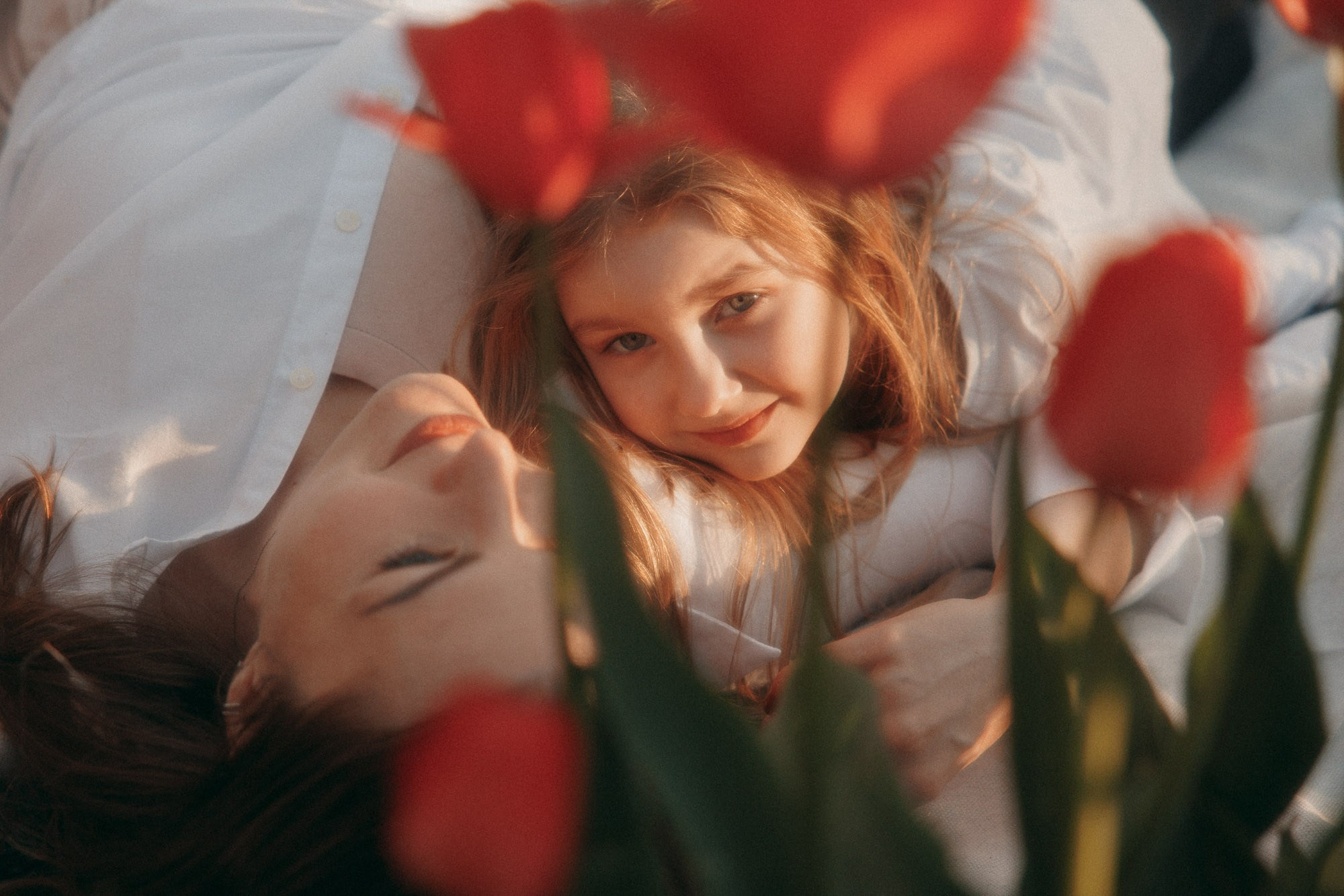 Girl lying among red tulips during a spring family session