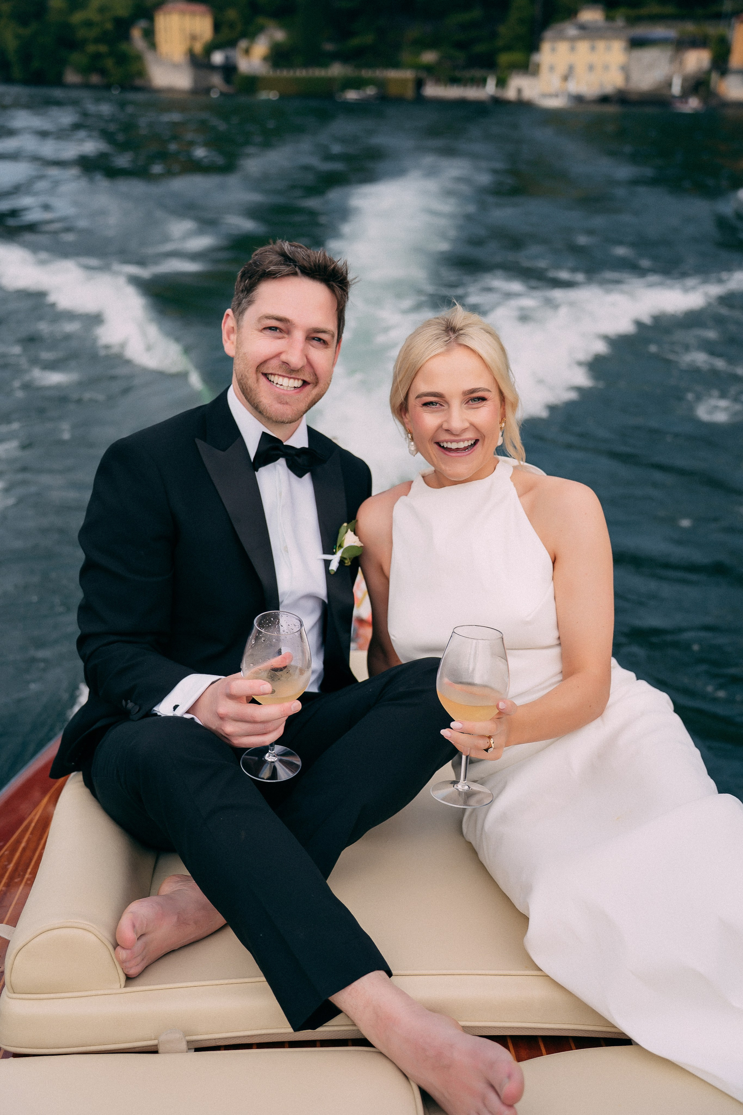 Bride and groom toasting with champagne on the boat at Villa Lario, Lake Como, Italy