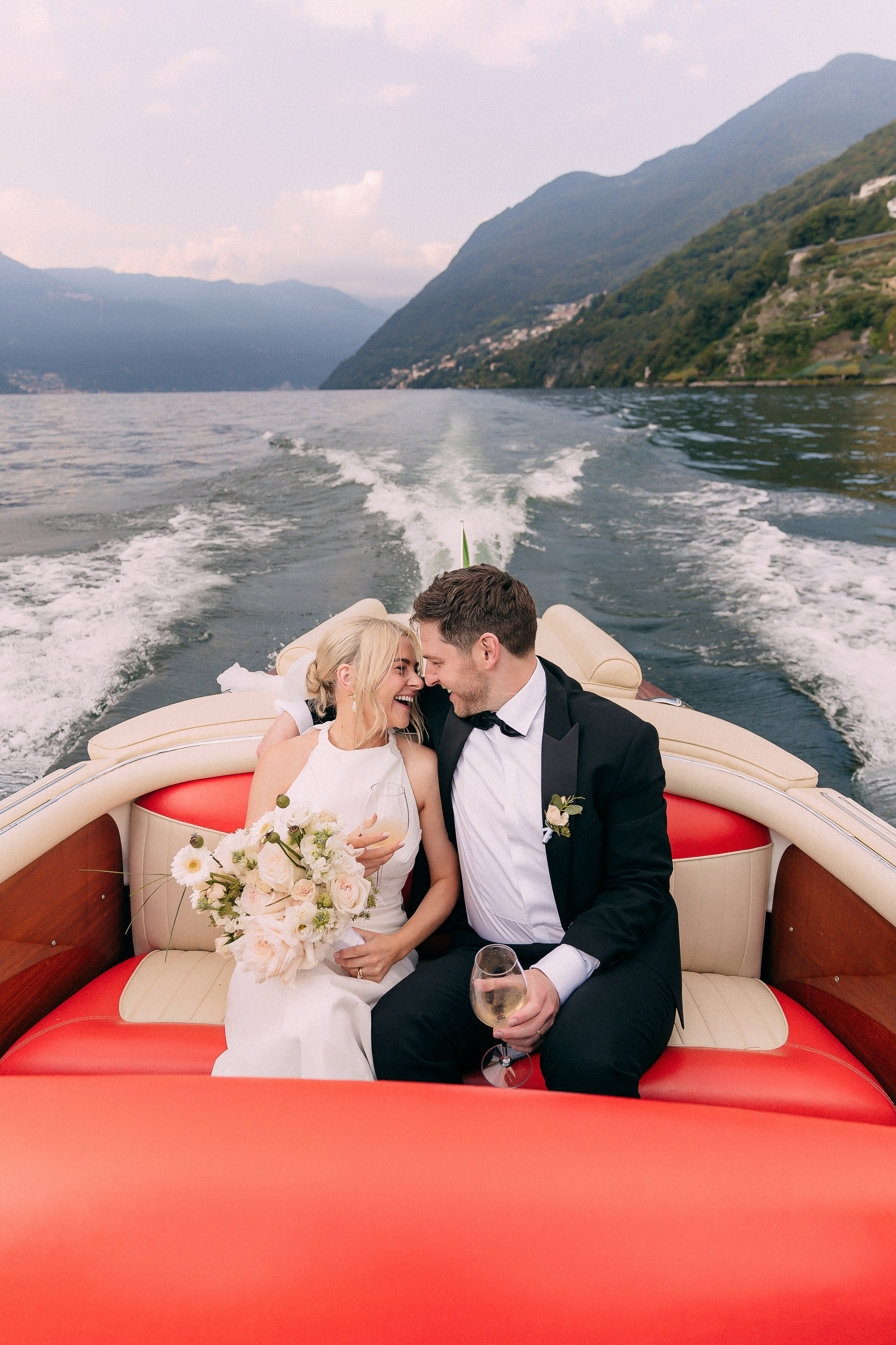 Bride and groom kissing on the boat at Villa Lario, Lake Como, Italy