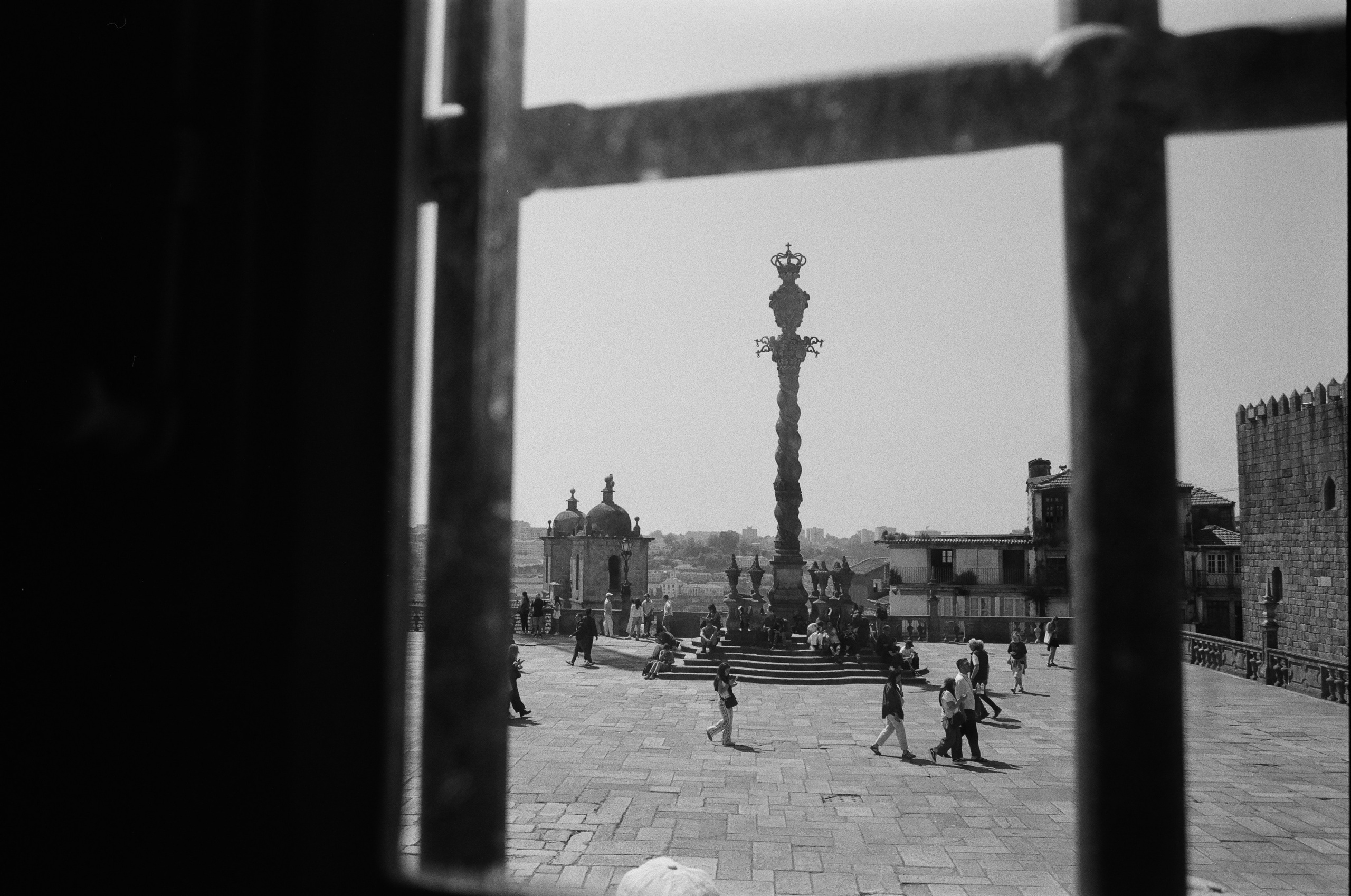 Blick durch ein Gitter auf die Säule auf dem Platz vor der Kathedrale in Porto