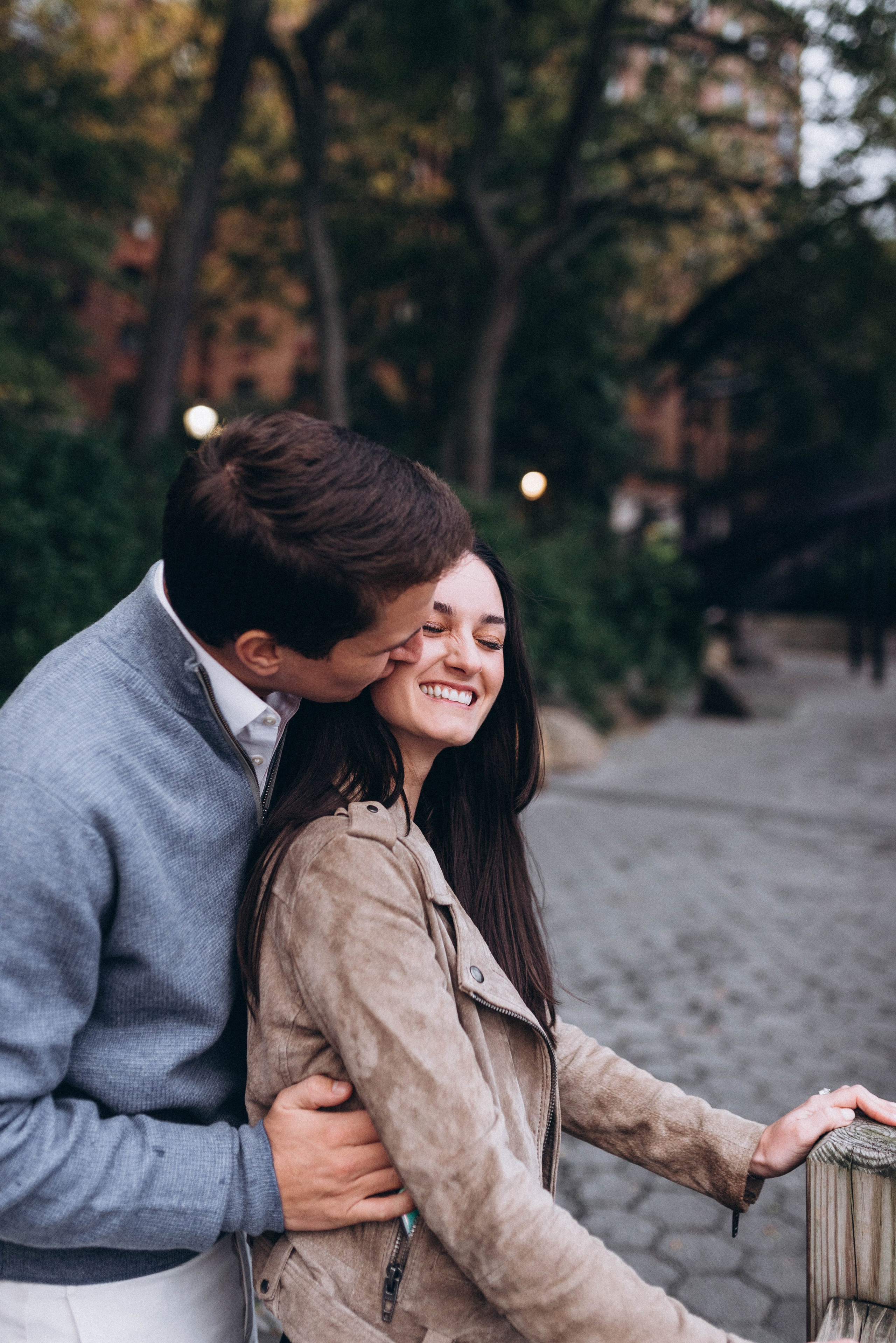 Bride-to-be excited near Central Park cherry trees.