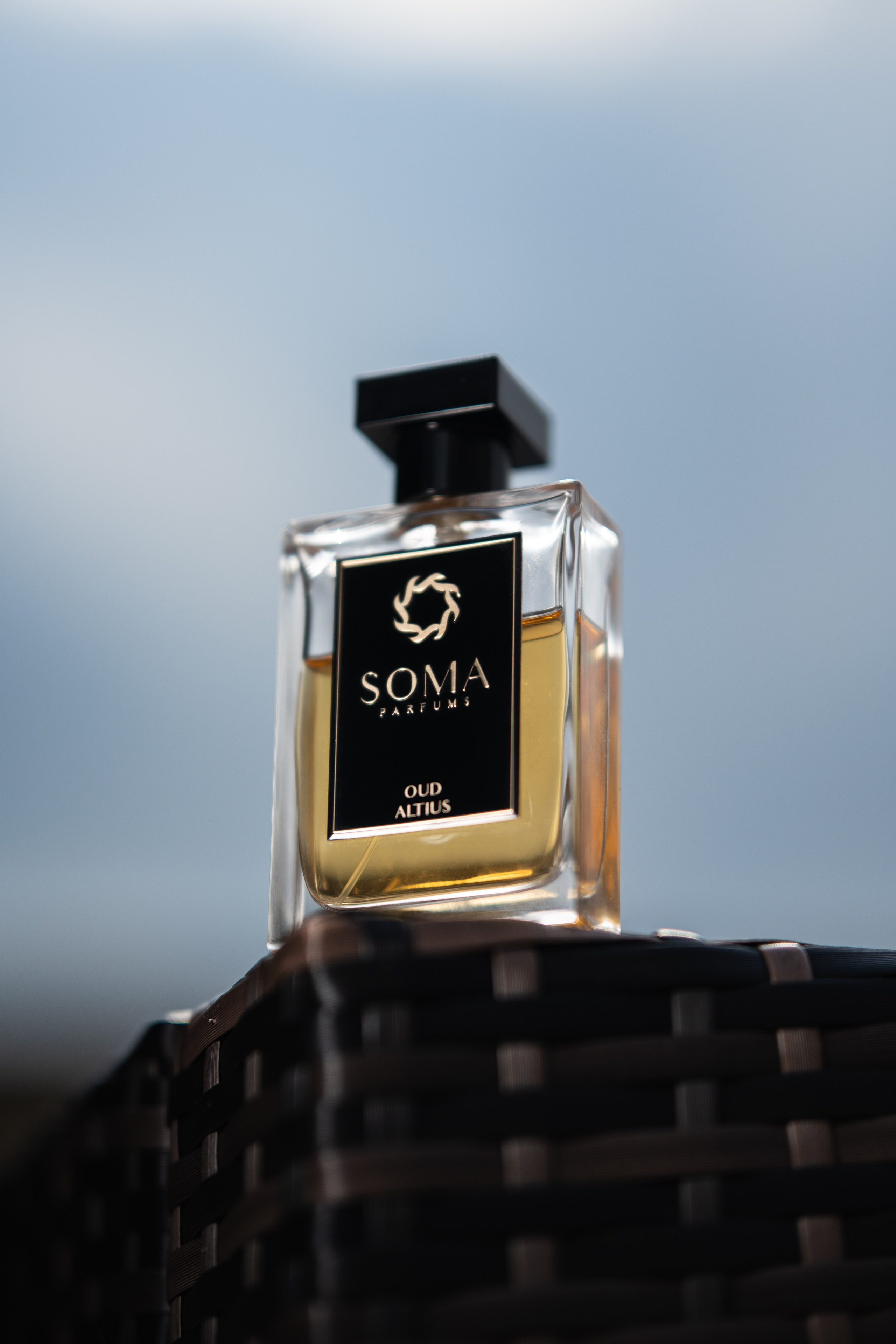 SOMA perfume bottle outdoors with dramatic light — lifestyle fragrance campaign imagery.