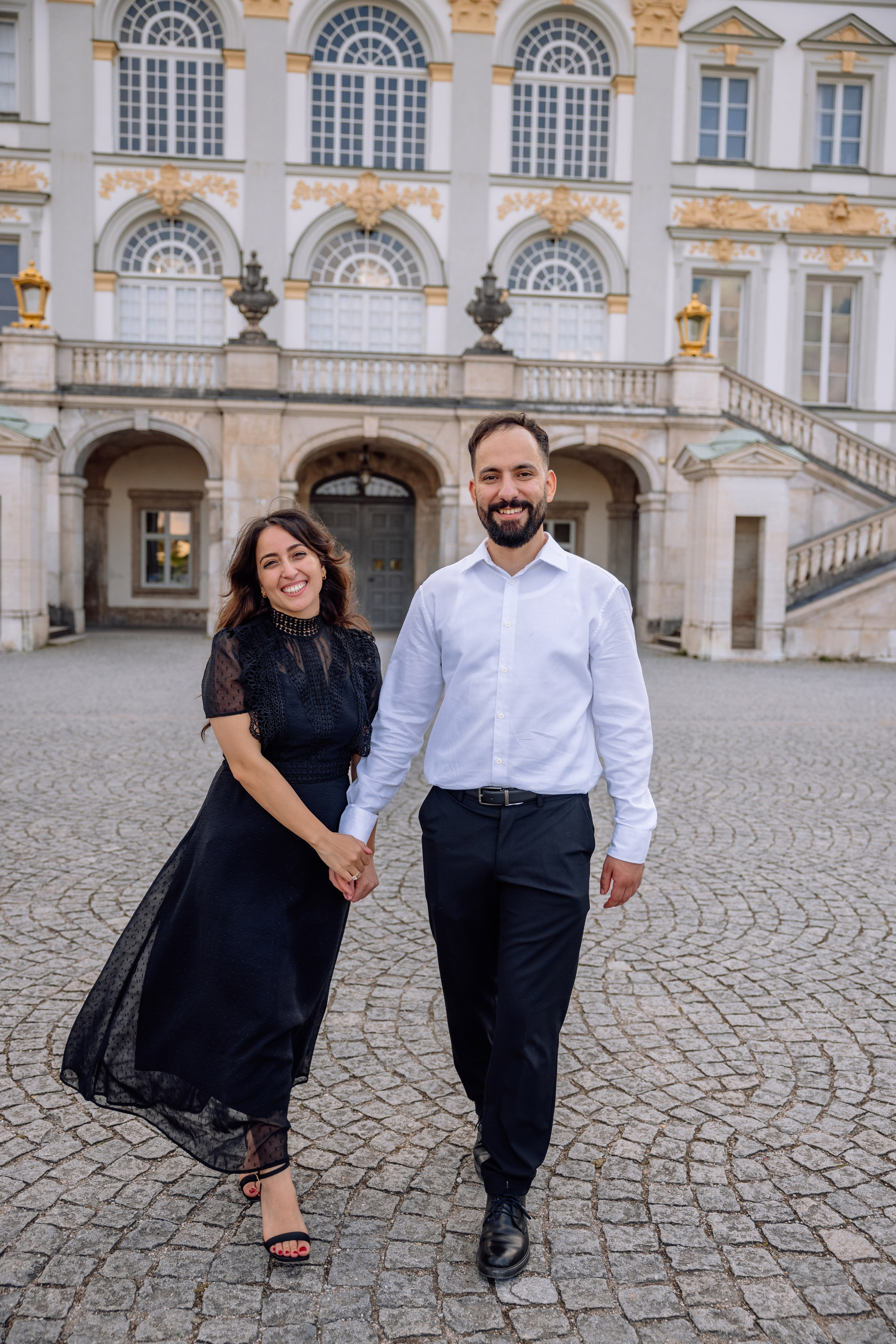 Paar läuft lachend über den Schlossplatz Nymphenburg