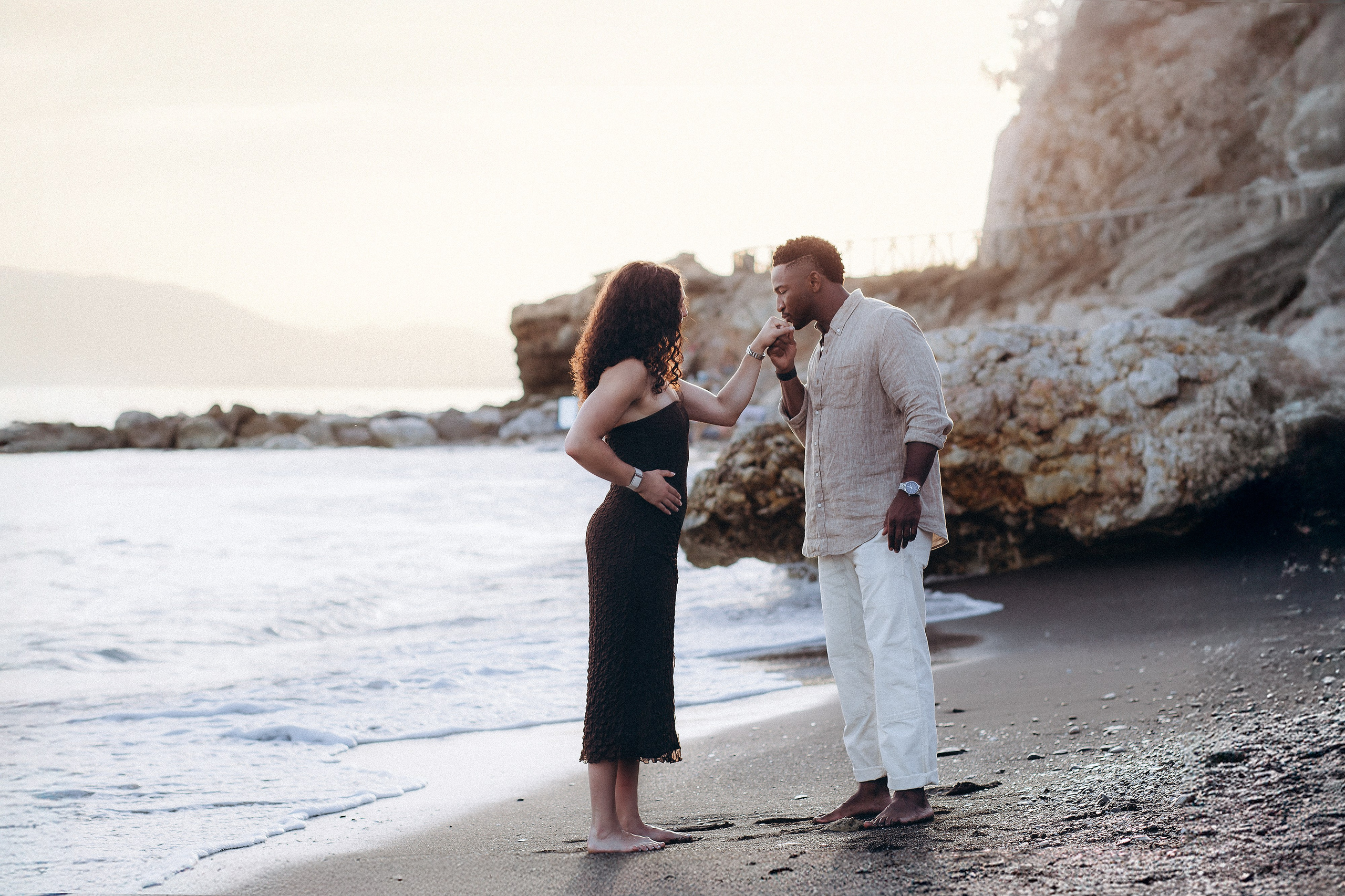 Romantic destination engagement session in Málaga with the couple standing by dramatic coastal cliffs after a heartfelt beach proposal. Natural light proposal photography on Spain’s Costa del Sol capturing intimate seaside moments.