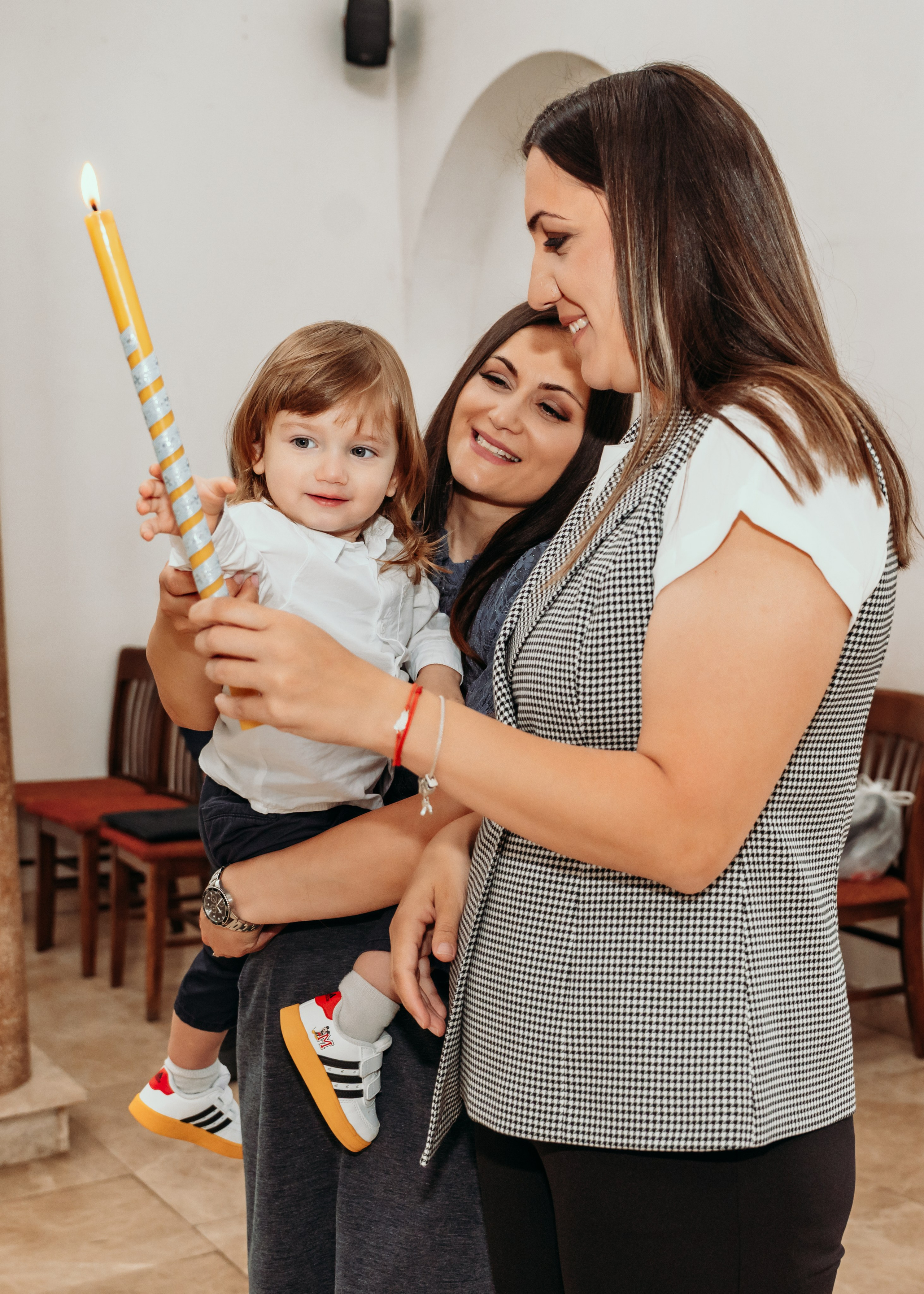 Mama i kuma drze bebu na krstenju u Beogradu