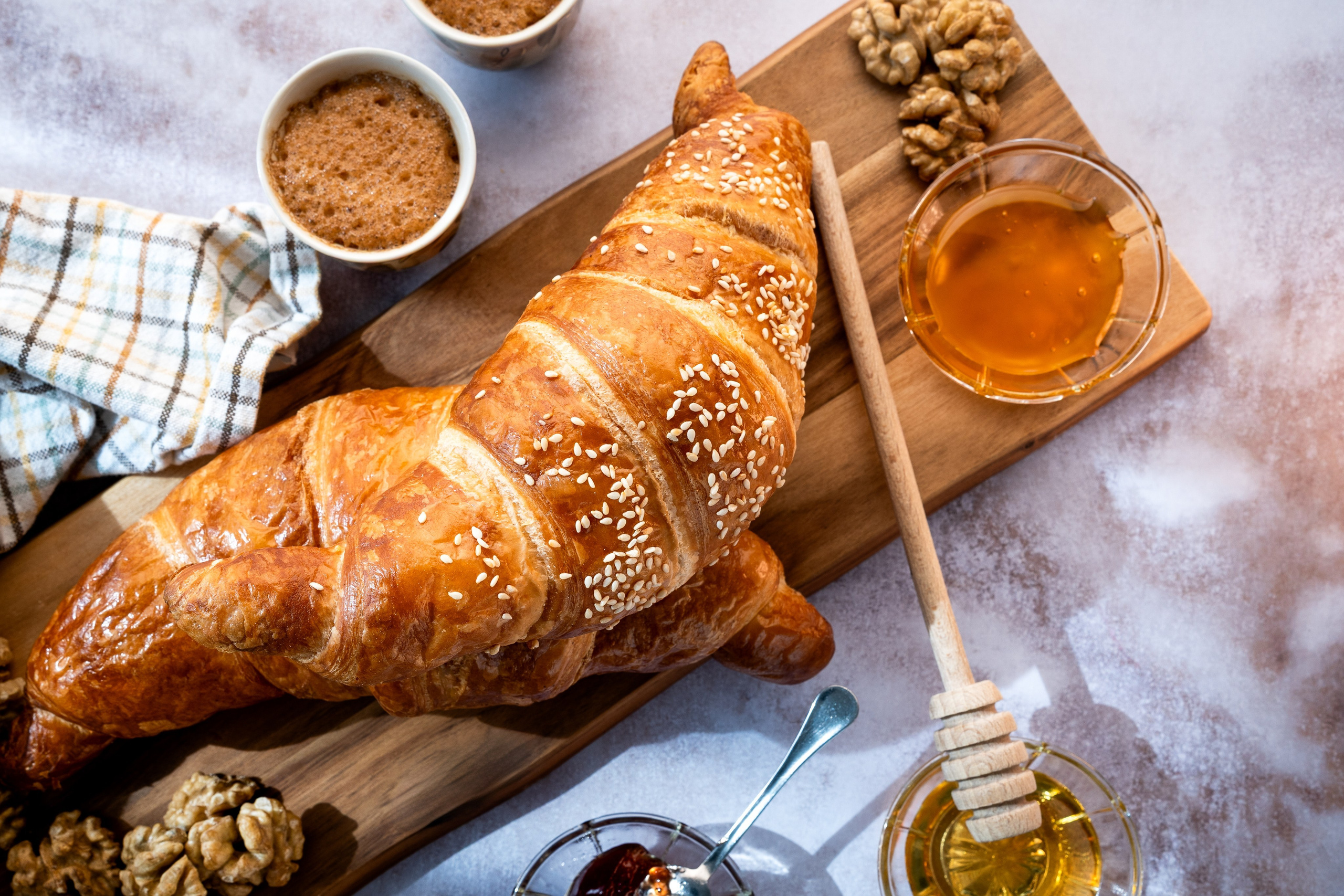 dva kroasana sa medom na stolu