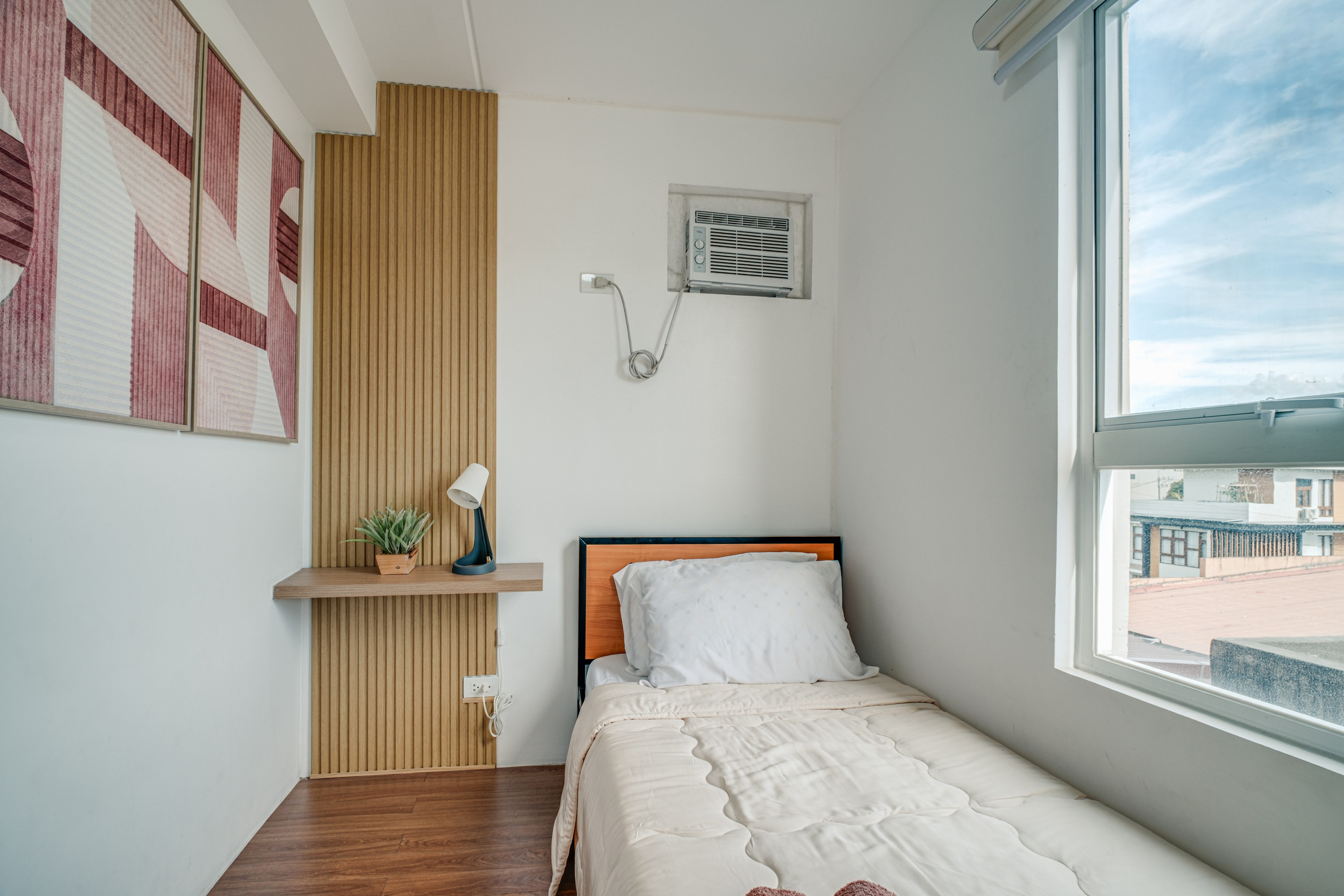 Professional interior photograph of a modern condo featuring a minimalist living room, dining area, warm wood finishes, and soft natural lighting.