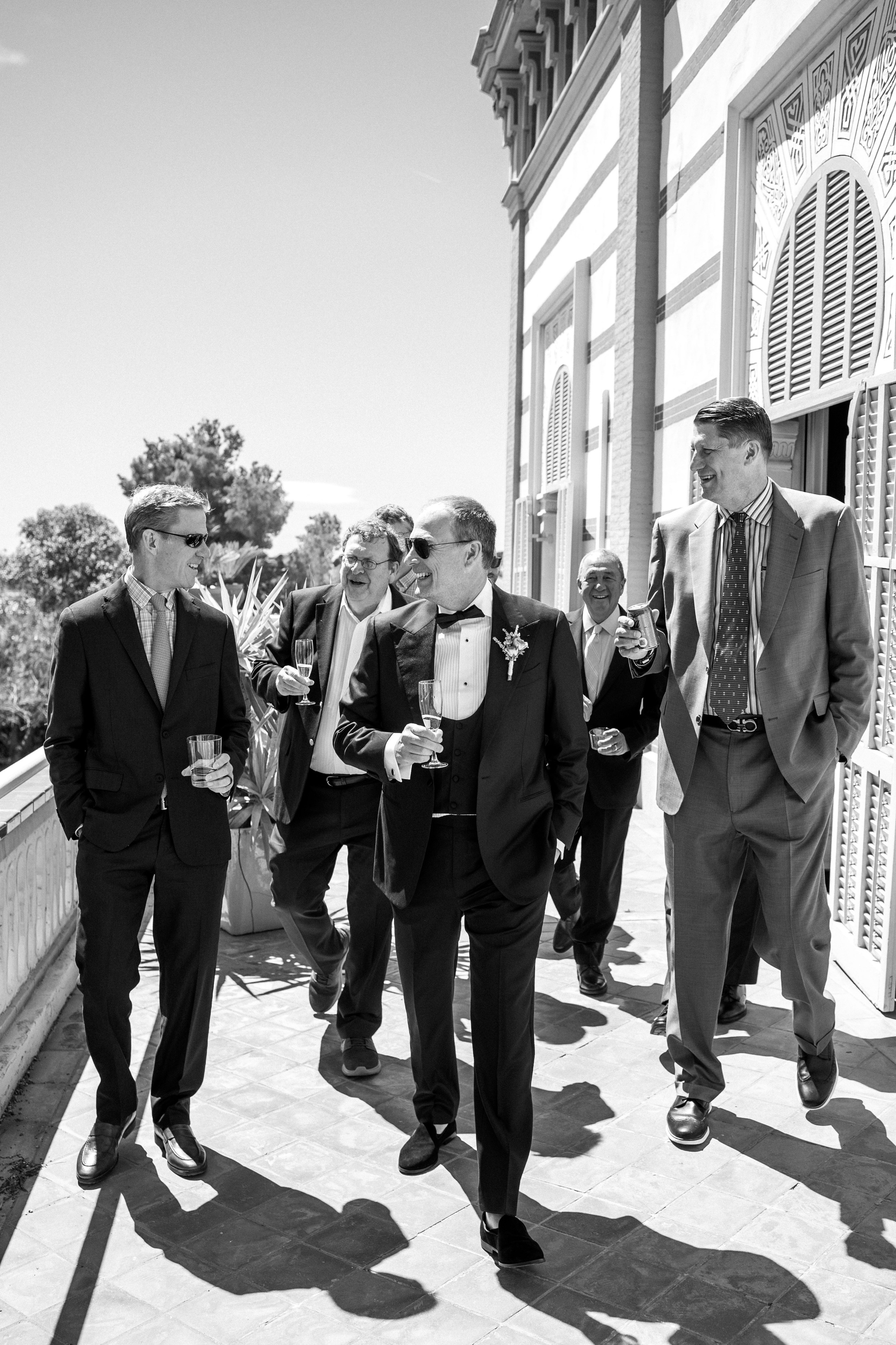 Candid shot of the groom laughing with friends during preparations for his wedding day in Barcelona