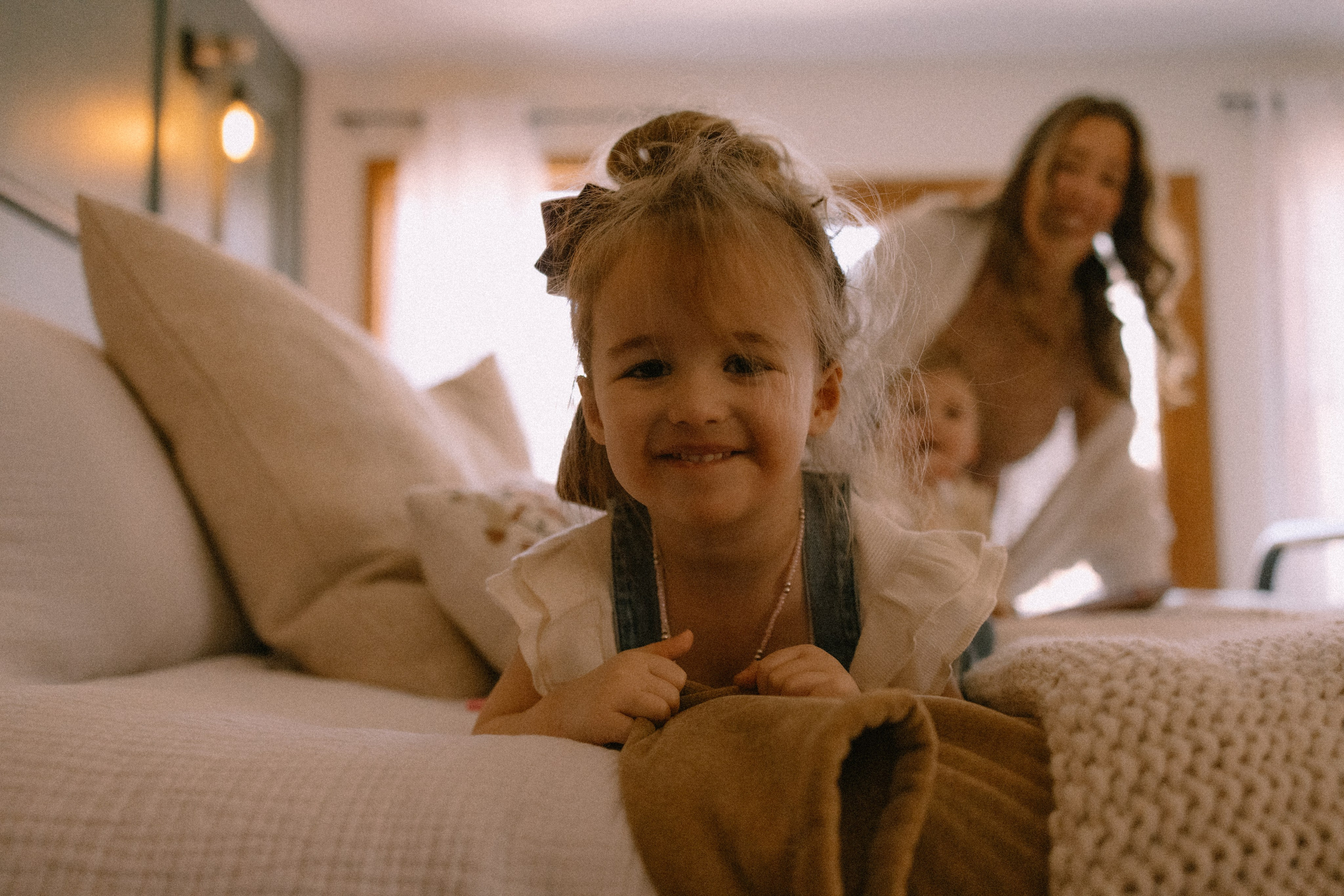 Child playing on the bed in joyful family photography session in South Jersey 