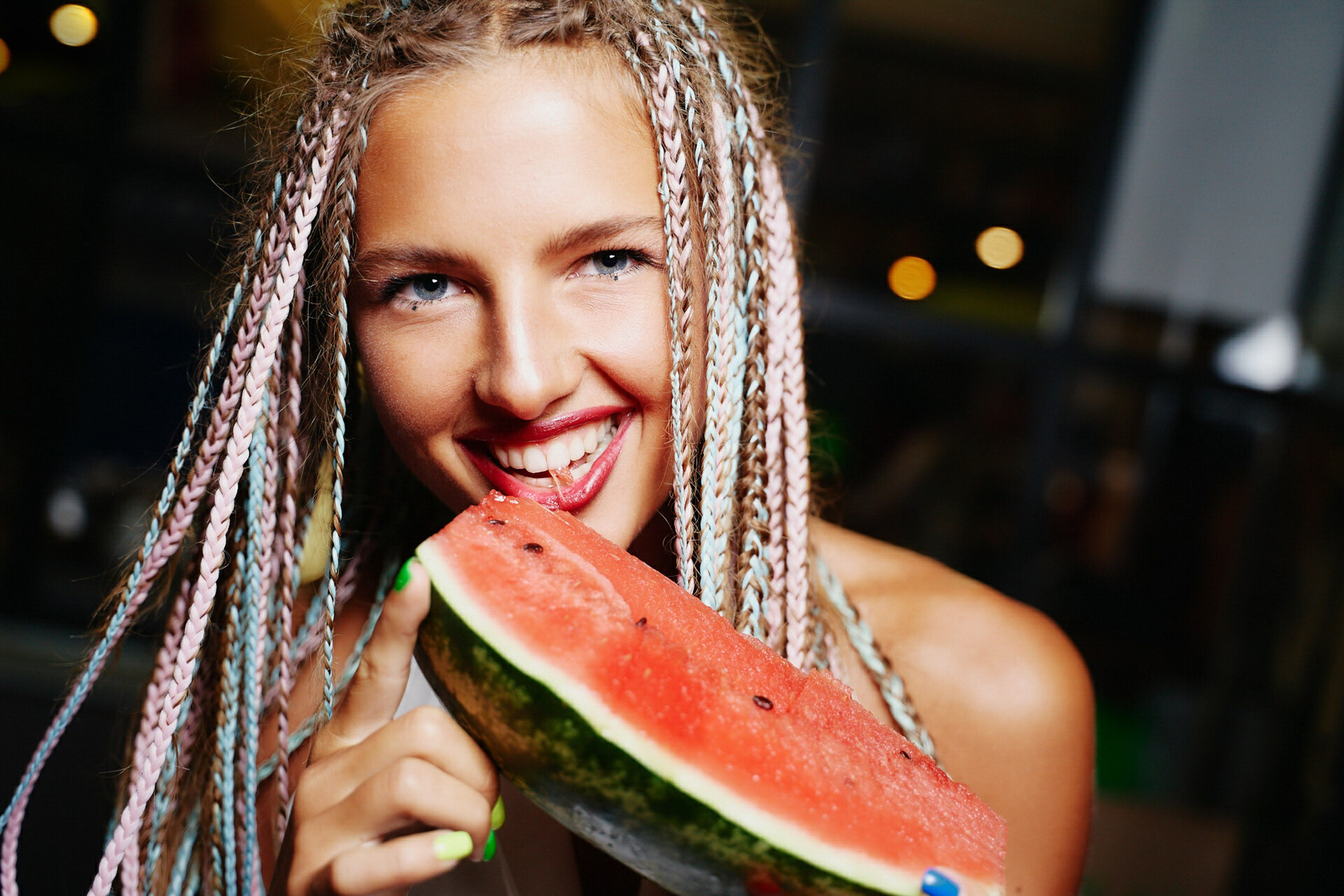 Woman with braided hair eating watermelon, fun summer moment