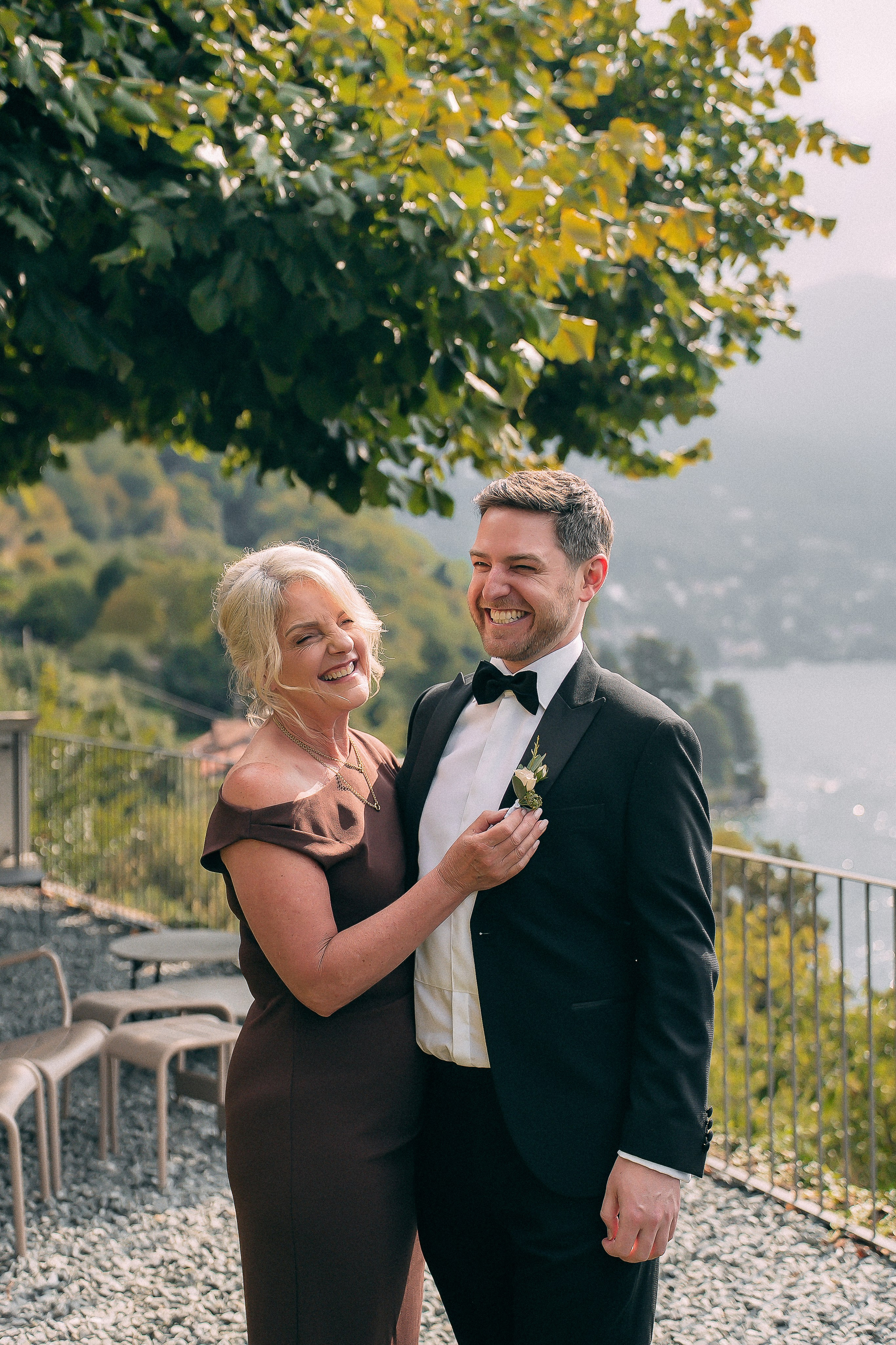 Groom holding a baby in the garden at Villa Lario, Lake Como, Italy