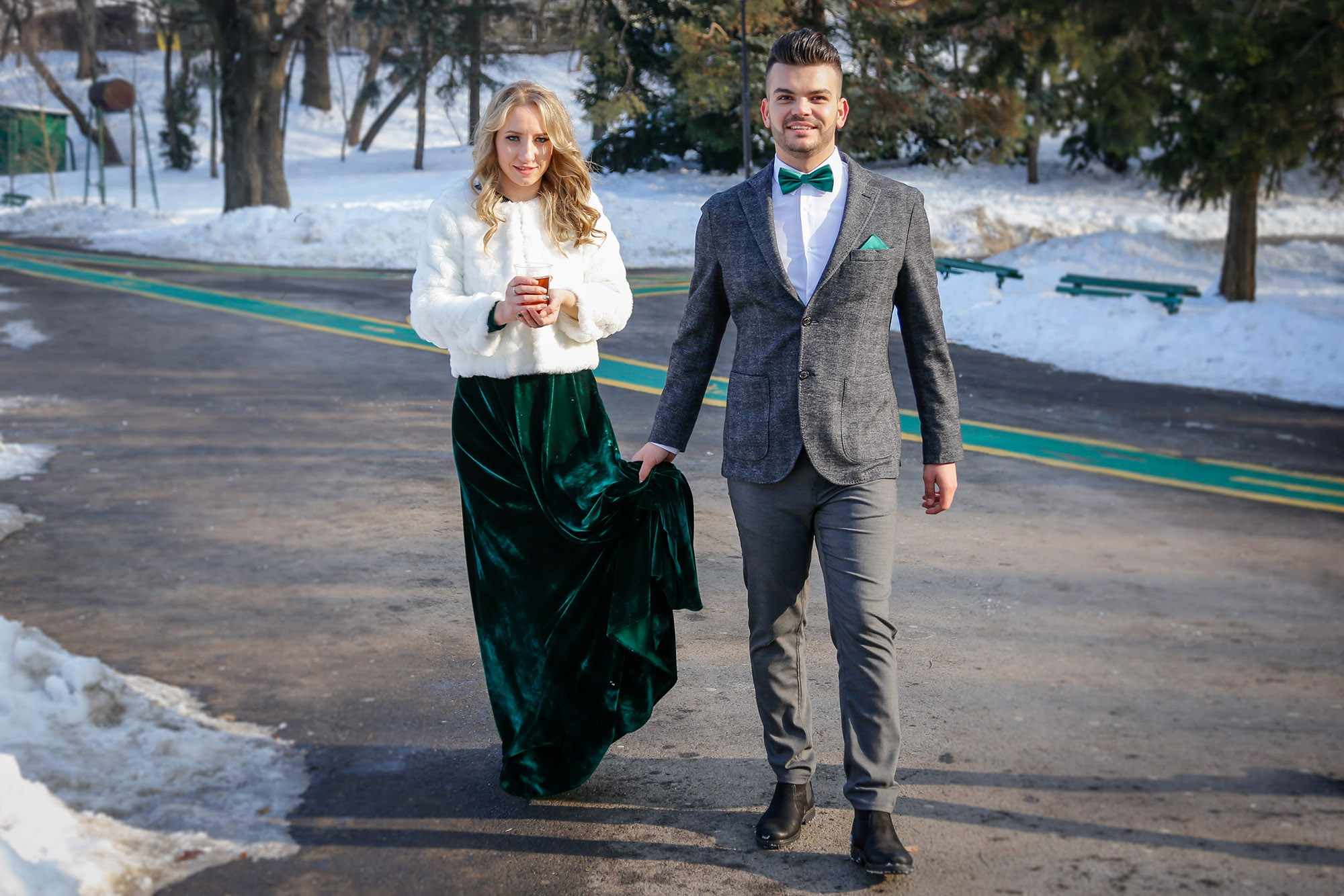 Newlyweds walking relaxed down a snowy park pathway, captured by the civil wedding photographer in a natural setting.