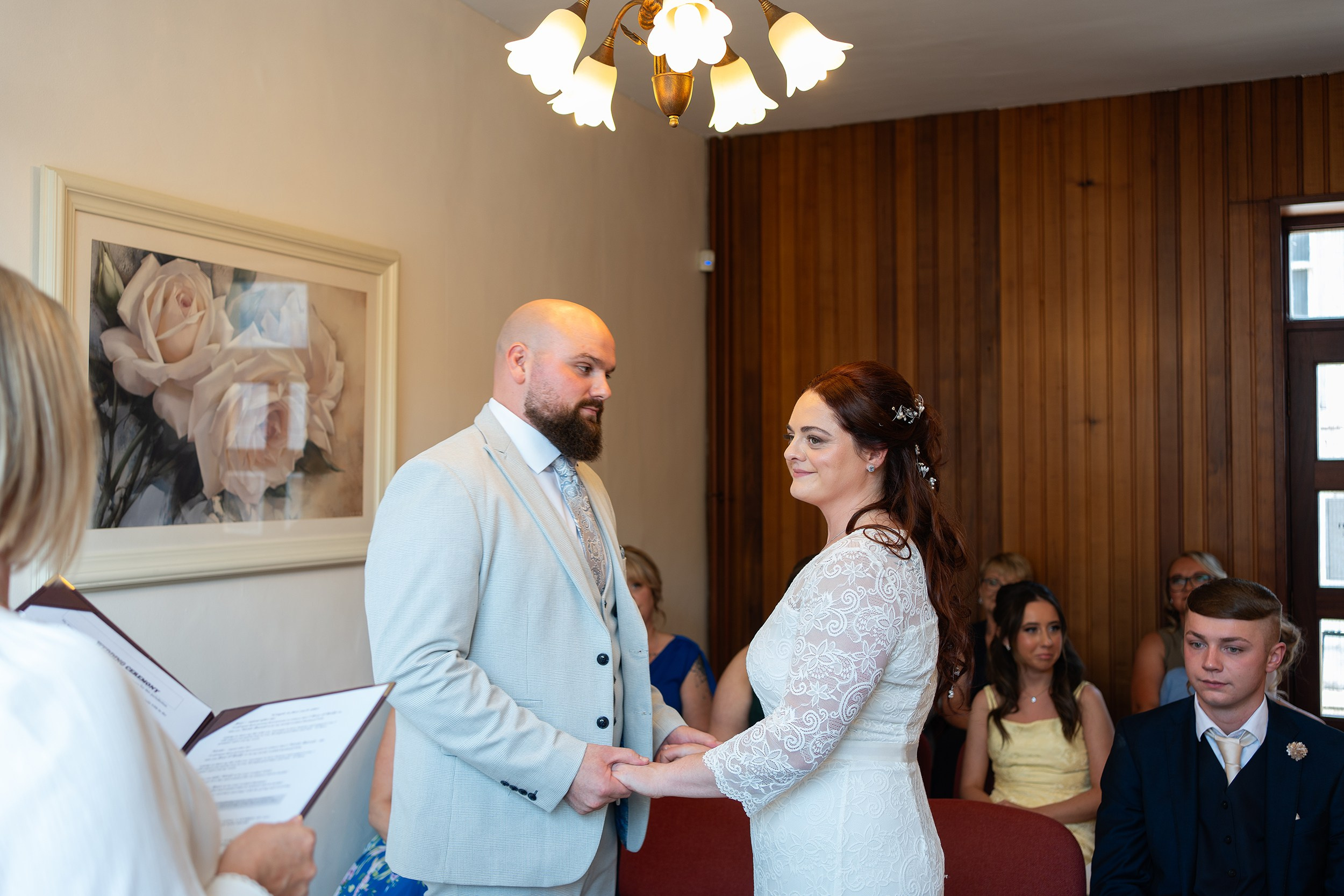 Bride and groom holding hands and exchanging vows during an intimate civil ceremony. Creative wedding photographer serving Cork