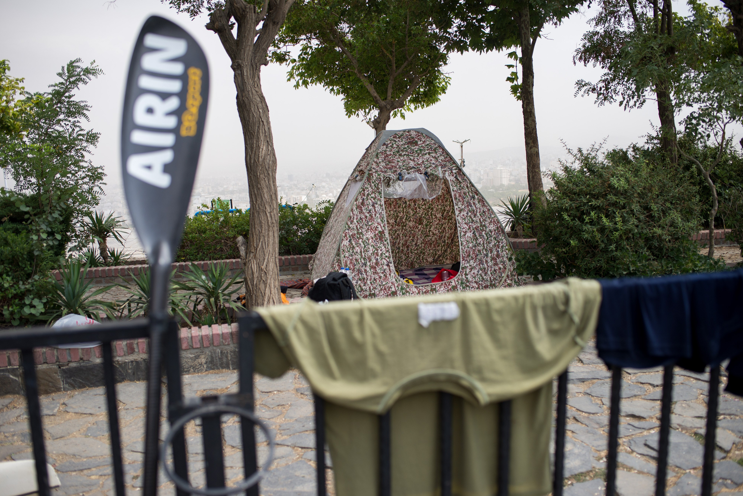 The team trains in a recreational pool. Because the team’s container is located some distance from the training area, a tent has been set up for the athletes, who hang their clothes on railings to dry after training.
