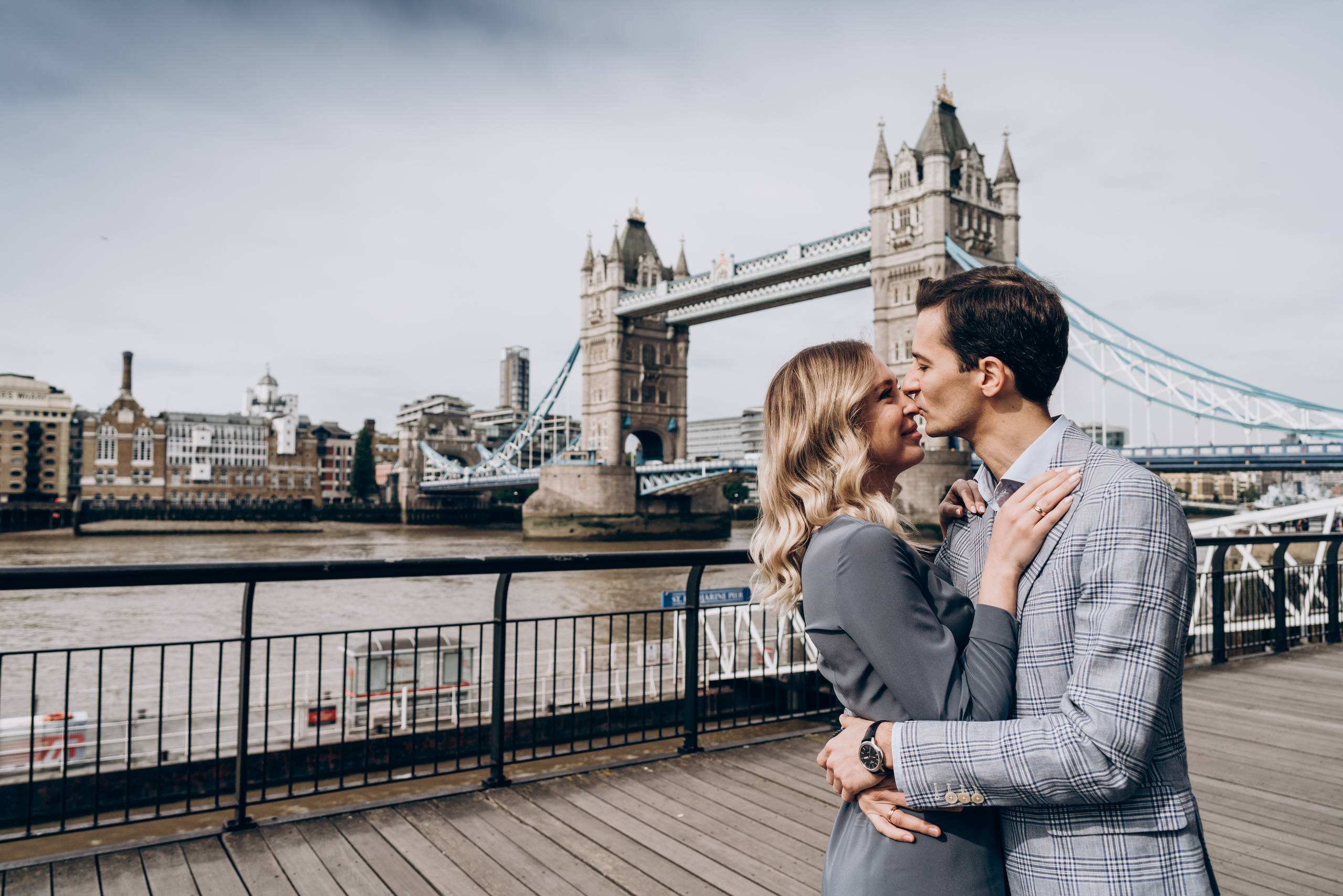 young couple is kissing by tower bridge 