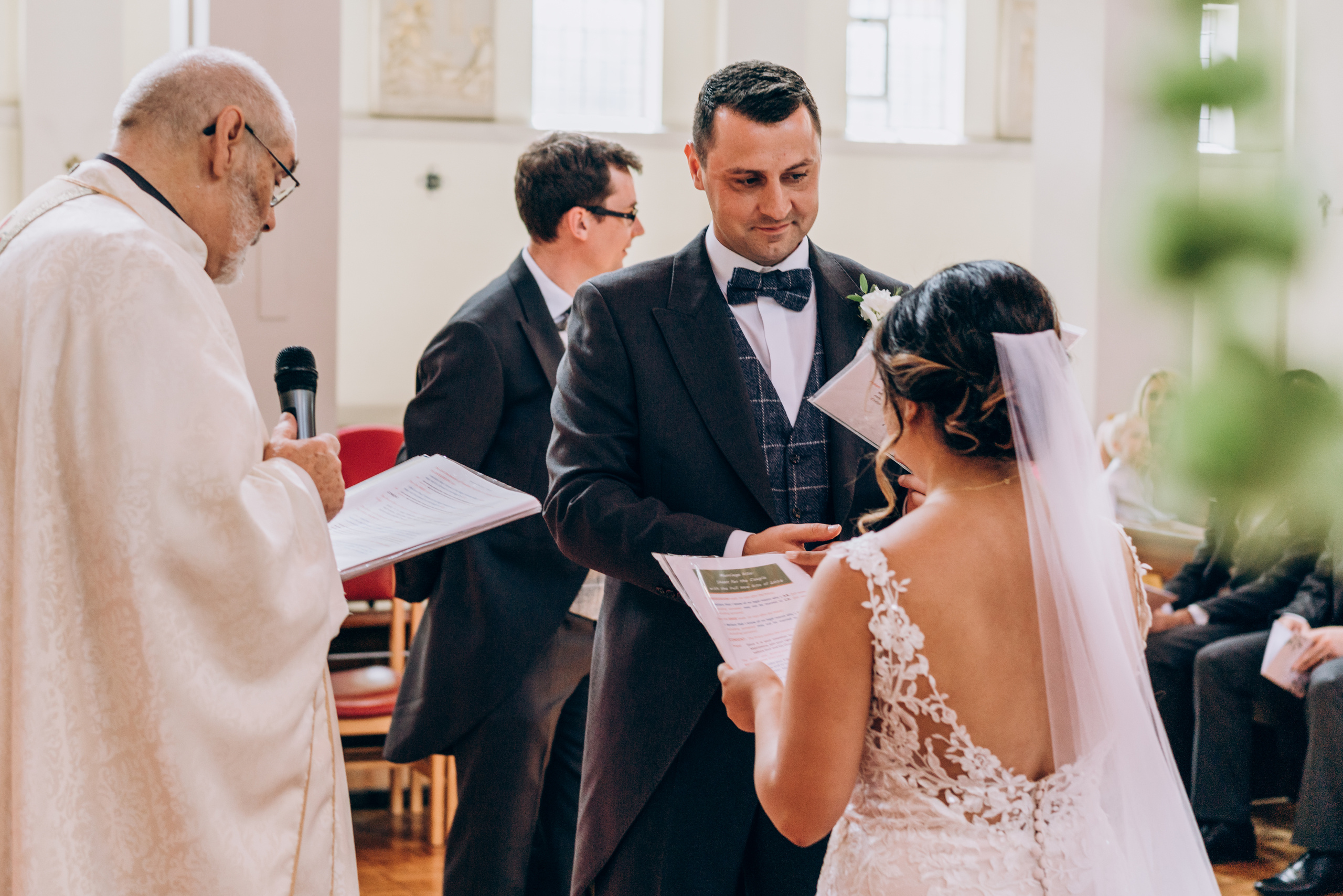 groom is swearing an oath holding bride's hand 