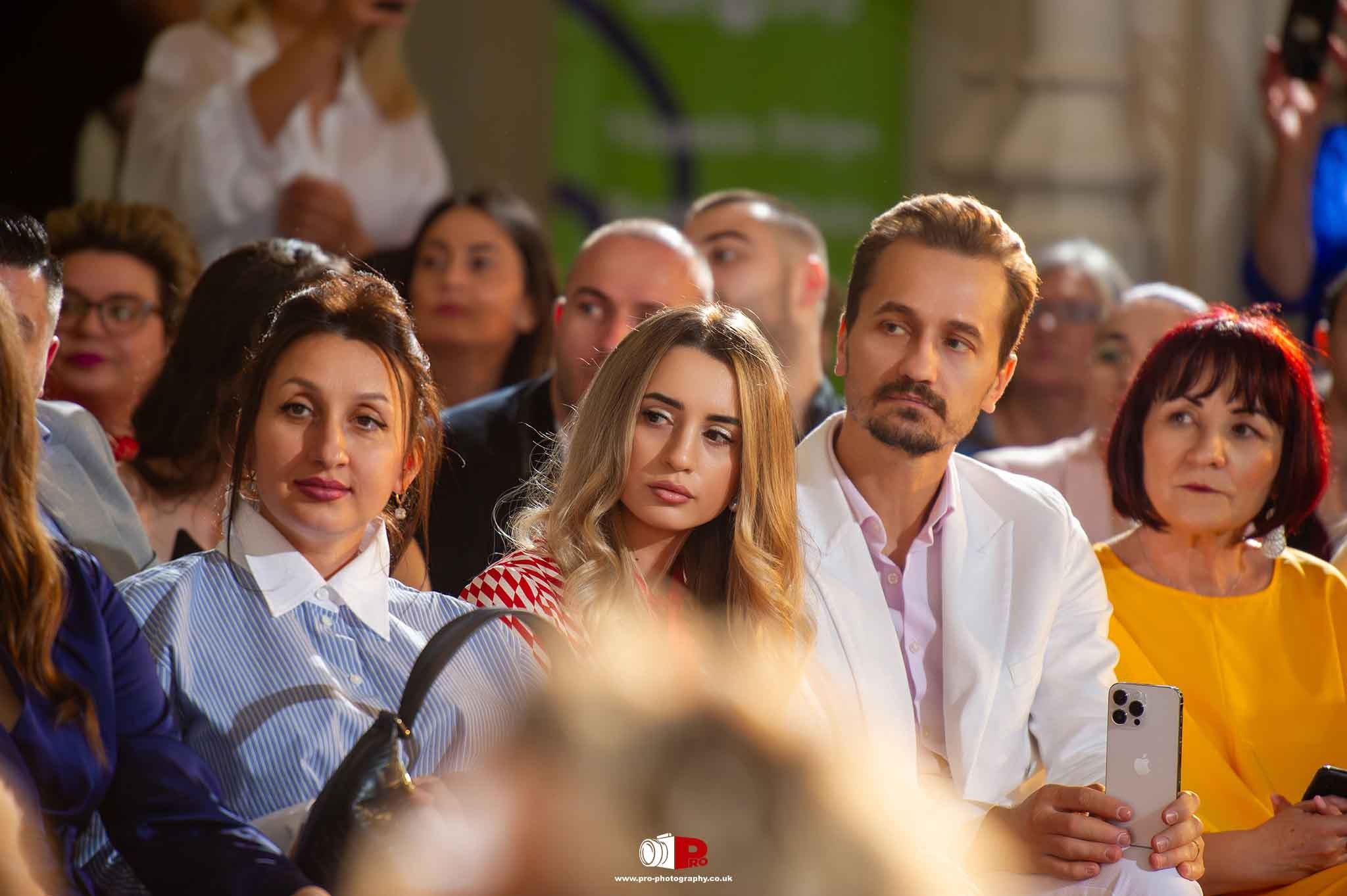 A posh audience is enjoying their evening at a formal gala dinner event with drinks and a lively crowd.