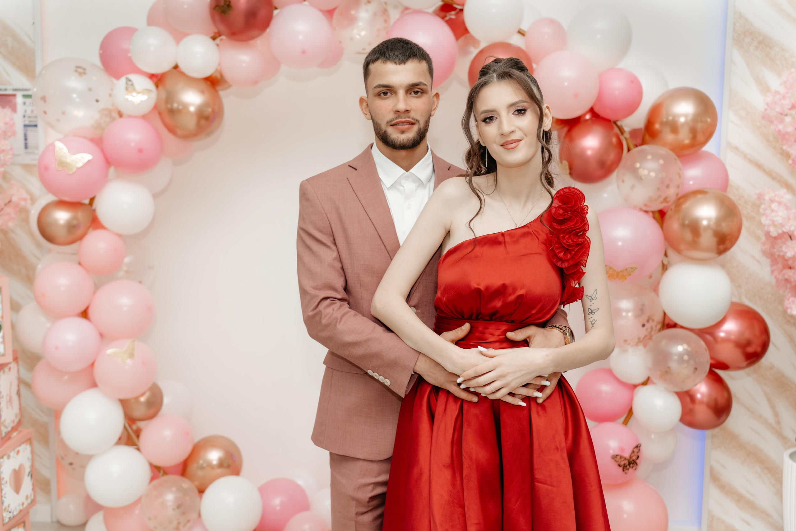 Părinții Evelinei Maria, Maria și Gabriel, stau împreună într-un moment de contemplare liniștită și mândrie, privind spre petrecere sau unul spre celălalt. O poză puternică care arată legătura și partenariatul lor, fotografiată cu sensibilitate la botez.