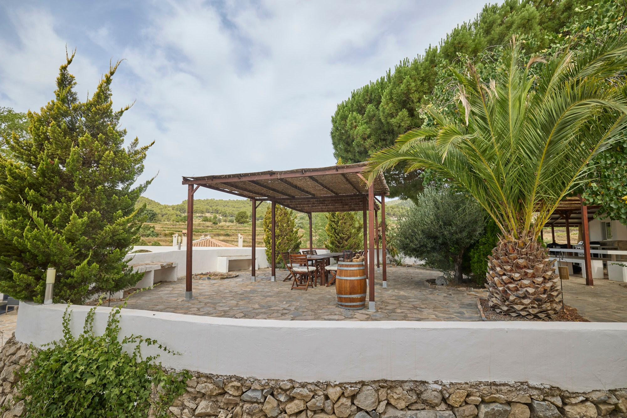 Jardín con pérgola y plantas mediterráneas junto a una vivienda en Valencia