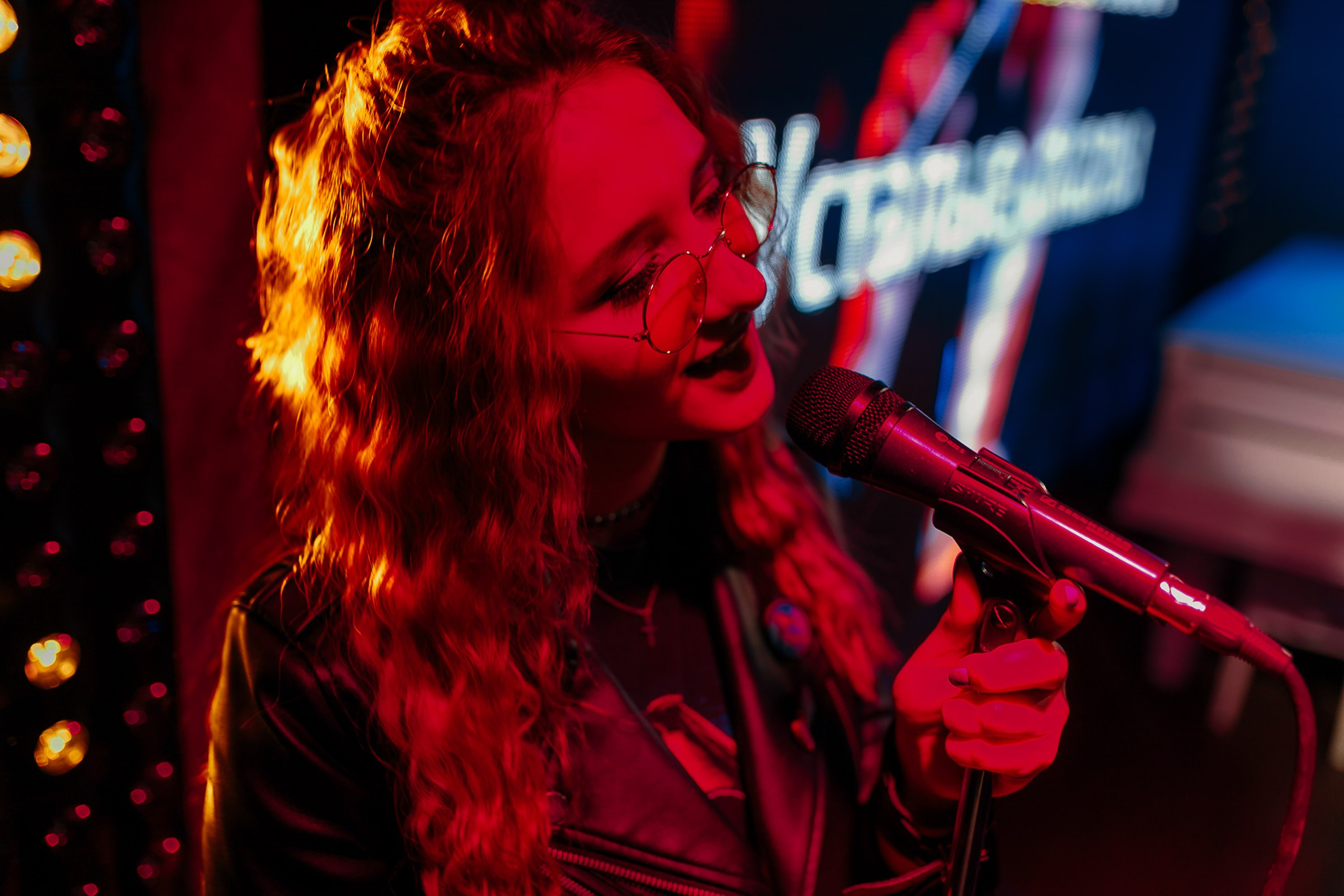 Woman smiling with neon lights in background, nightlife portrait