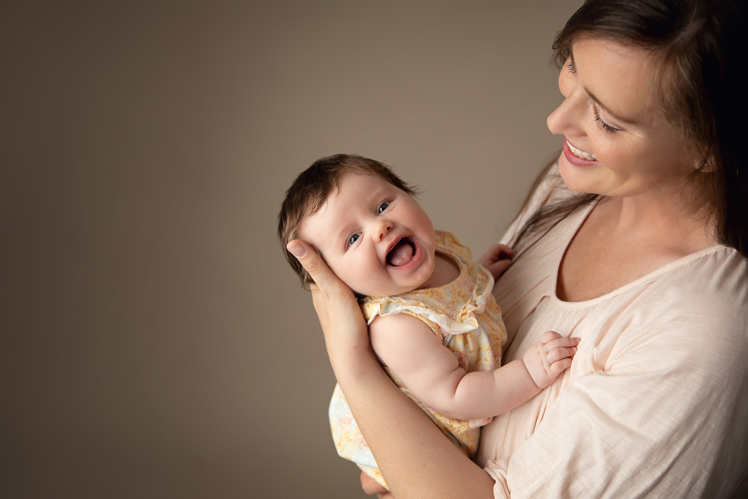 En familjefotografering i vår fotostudio fångar alla de äkta leendena och den speciella gemenskapen mellan mamma, pappa och barn.