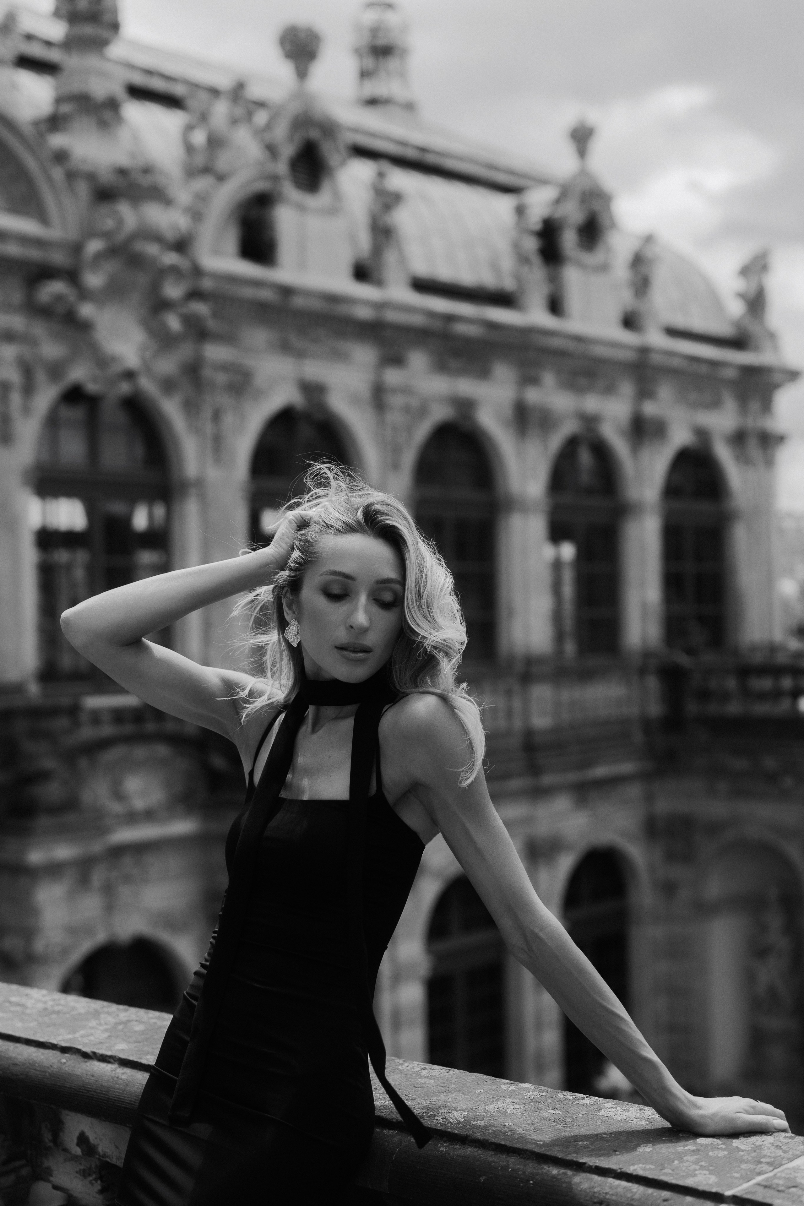 Elegant black and white portrait of a woman posing in front of historic palace architecture in Dresden, Germany. Fine art female portrait photography by a black and white portrait photographer serving Dresden, Leipzig and Wurzen. Элегантный чёрно-белый портрет девушки на фоне исторической дворцовой архитектуры Дрездена, Германия. Художественная женская портретная фотография от фотографа, специализирующегося на чёрно-белых портретах в Дрездене, Лейпциге и Вурцене.