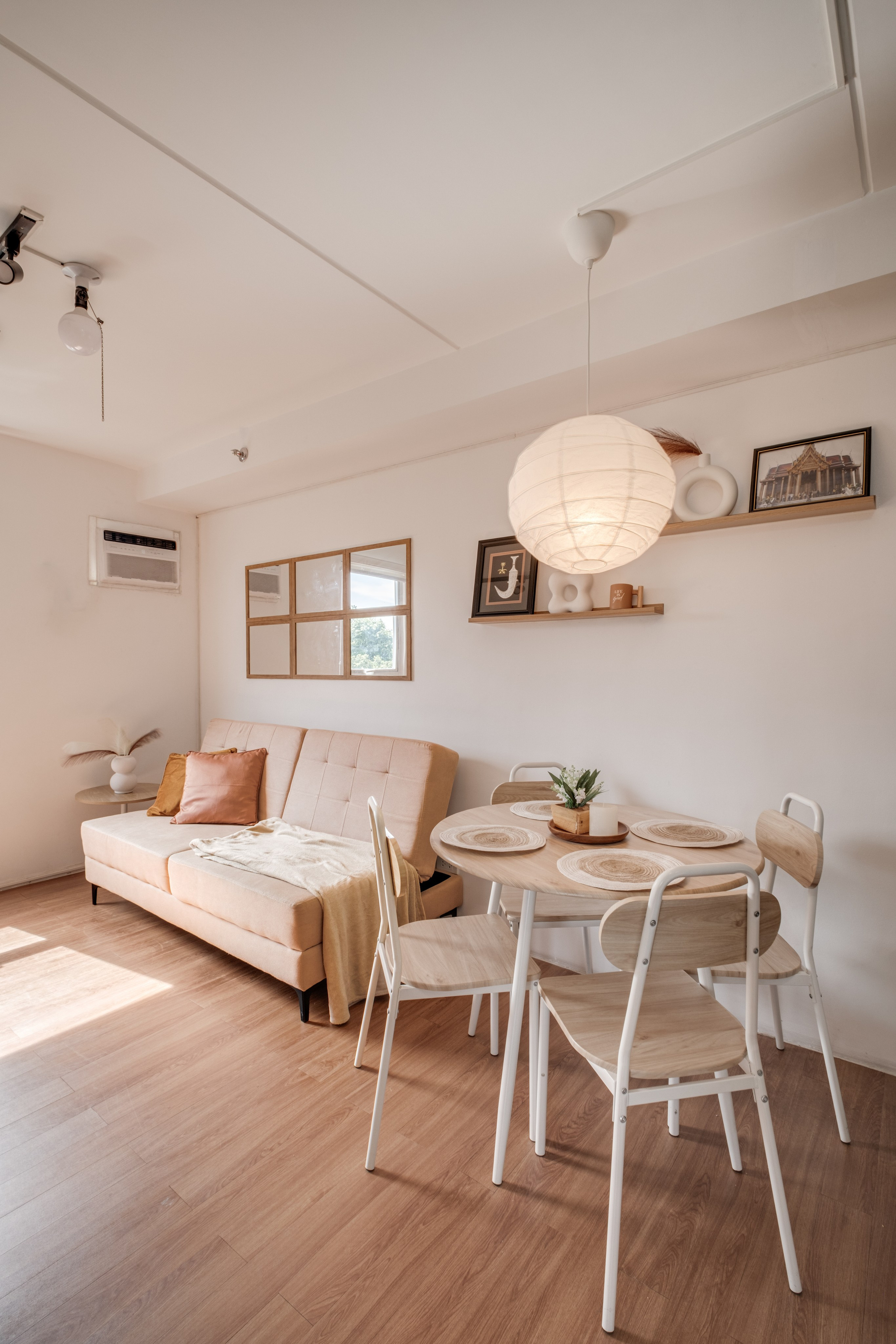 Professional interior photograph of a modern condo featuring a minimalist living room, dining area, warm wood finishes, and soft natural lighting.