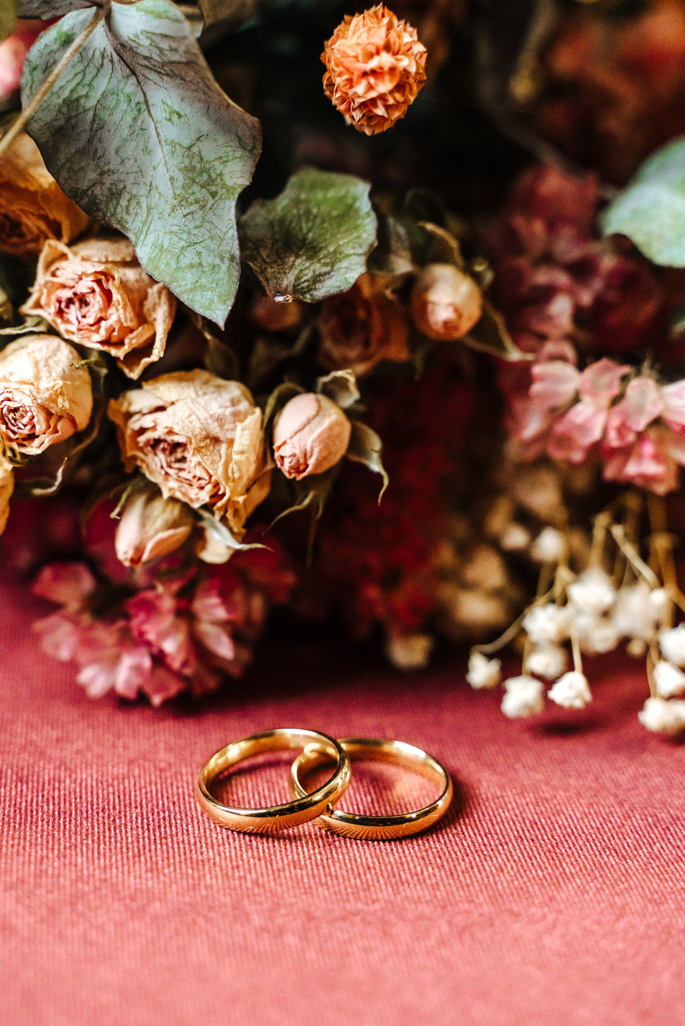Wedding rings surrounded by autumn flowers, photographed before Peter and Virginia's civil wedding ceremony.