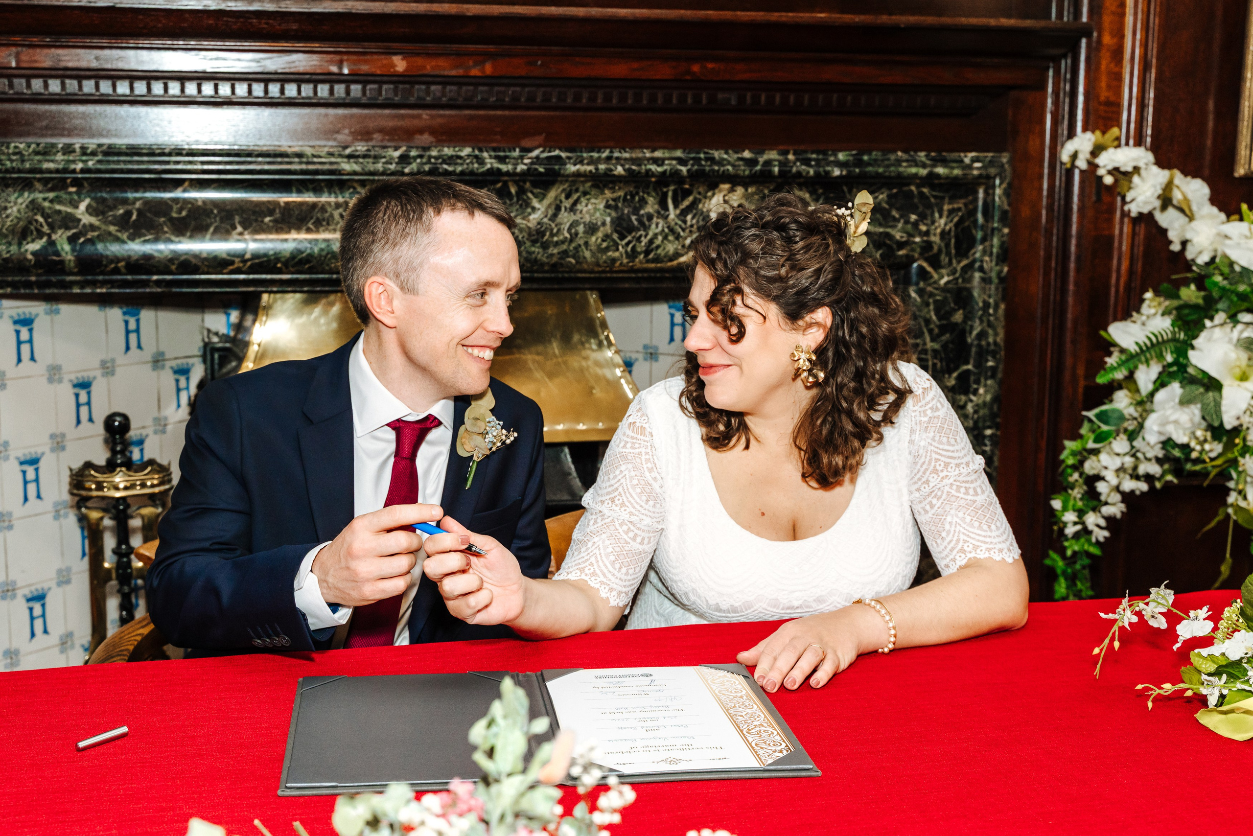 Groom and Bride signing their marriage register during their civil wedding ceremony in Henley-on-Thames.