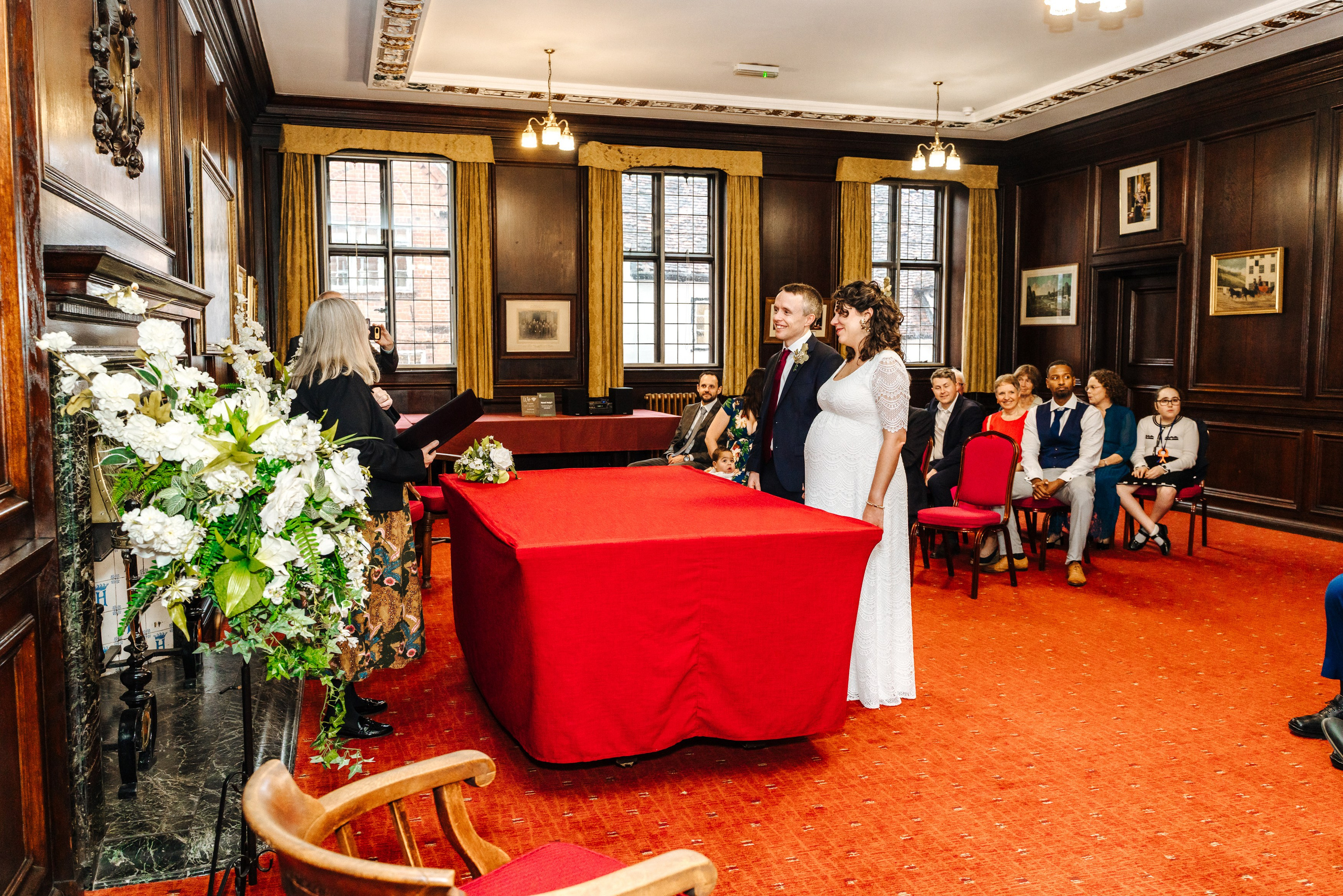 Peter and Virginia during their civil wedding ceremony at Henley-on-Thames Town Hall, with family and friends watching.