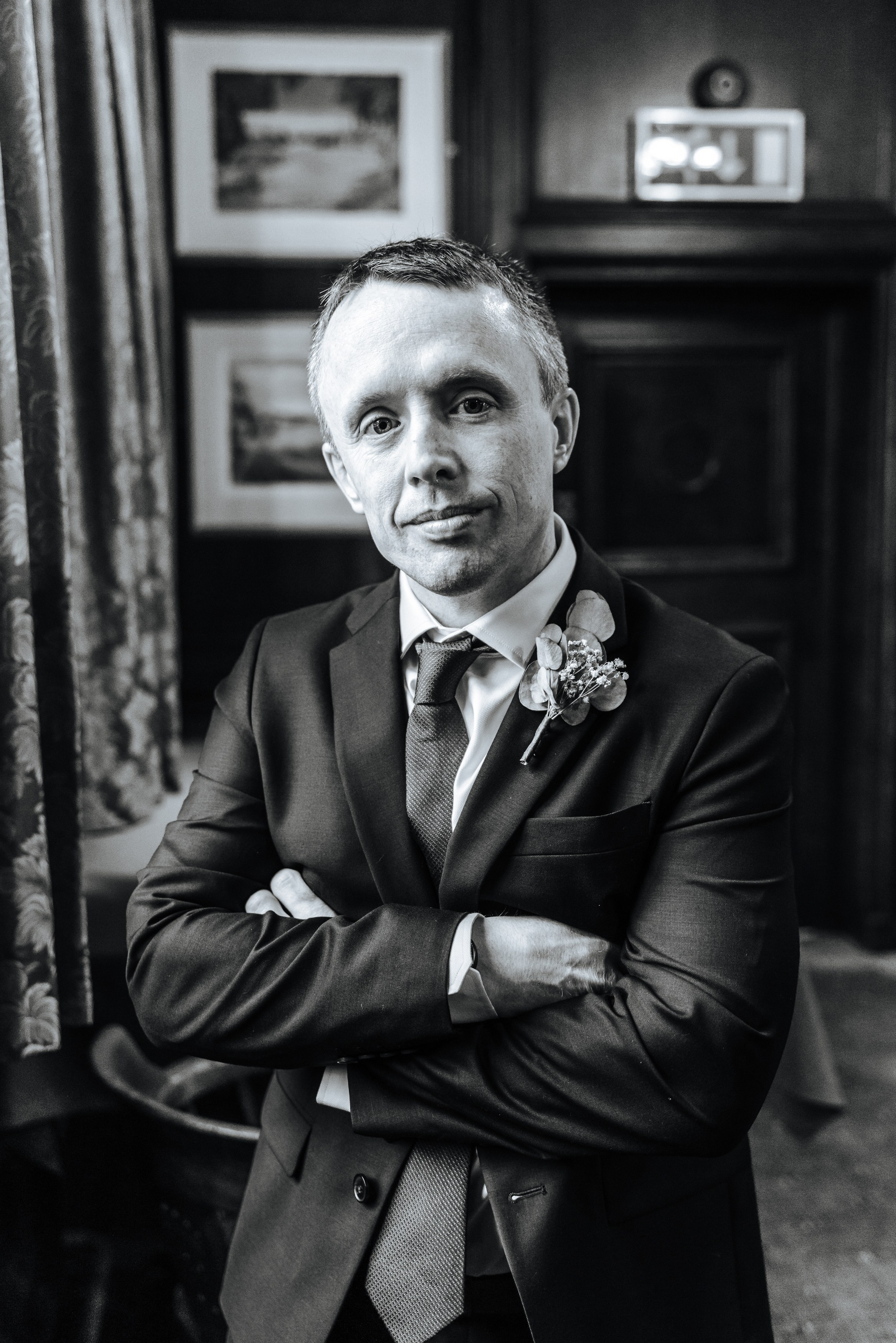Groom Peter in a navy suit and red tie, photographed inside Henley-on-Thames Town Hall.