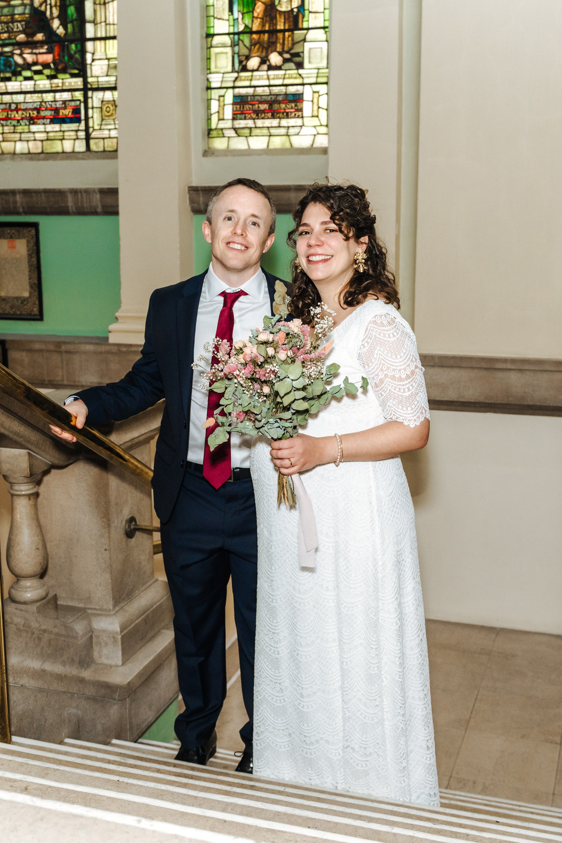 Groom and Bride posing together on the staircase inside Henley-on-Thames Town Hall.
