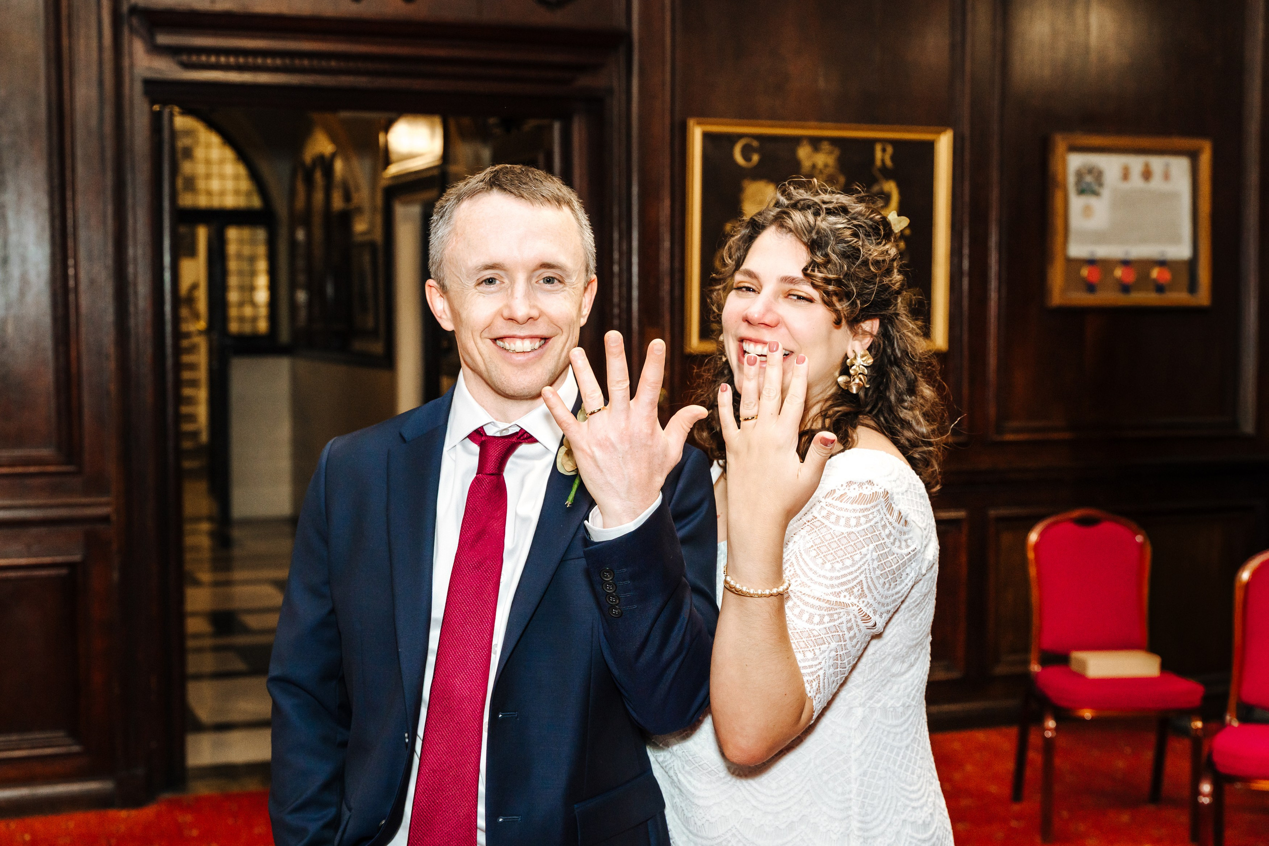 Groom and Bride showing their wedding rings in a joyful portrait at Henley-on-Thames Town Hall.