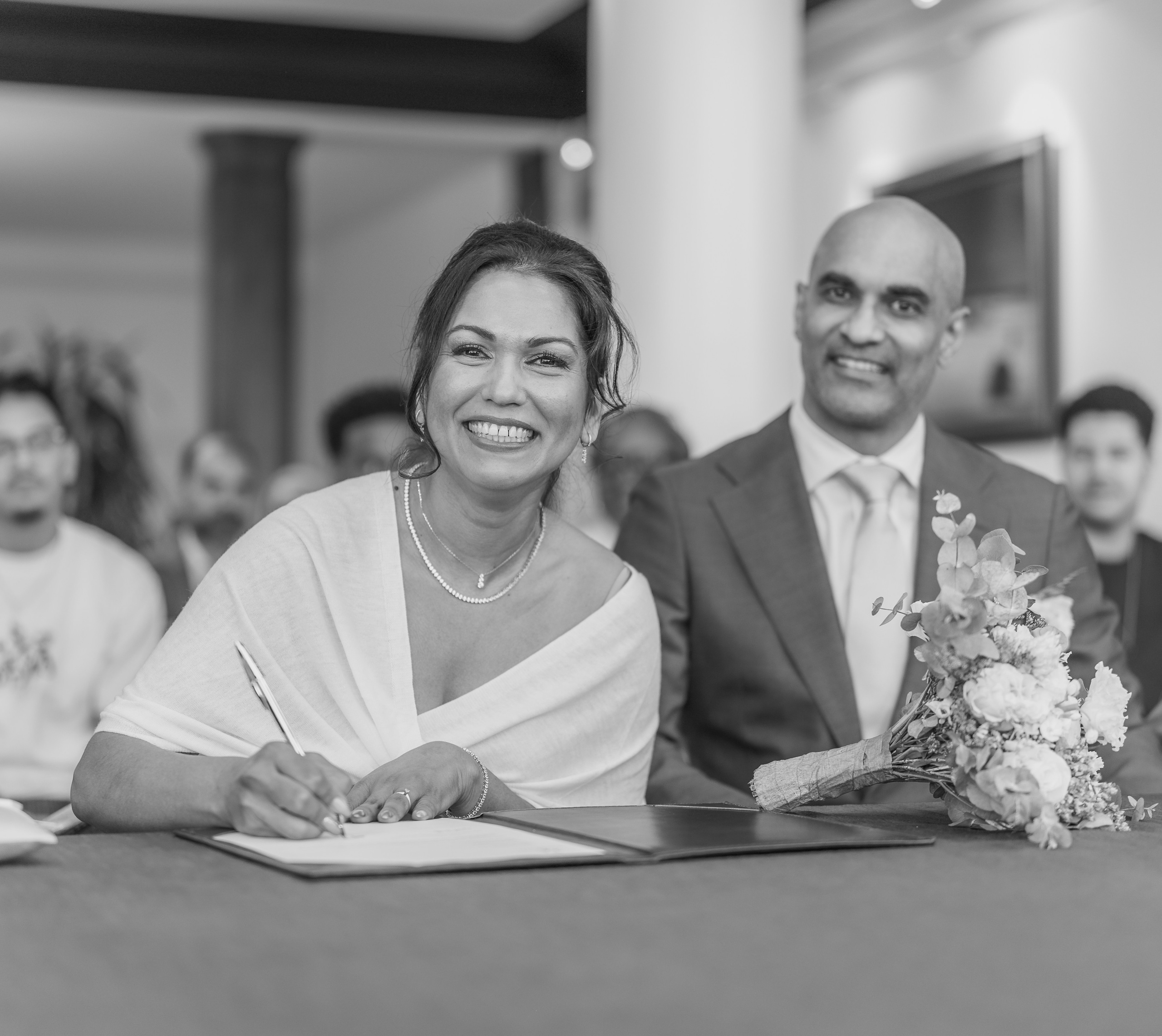 Kapture Fotografie - Koppel dat de huwelijksakte al lachend ondertekent in het gemeentehuis