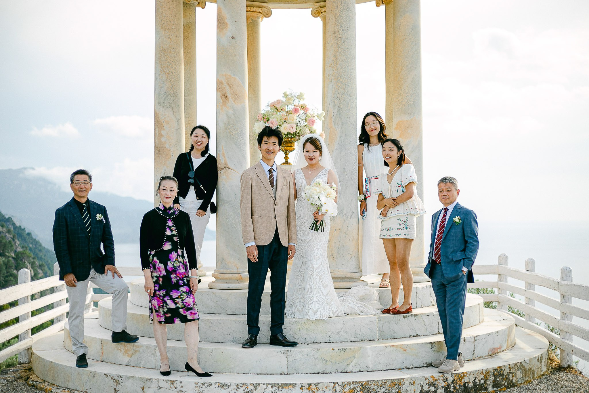 Bride, groom, and family posing at the Son Marroig temple after their exclusive Mallorca wedding ceremony