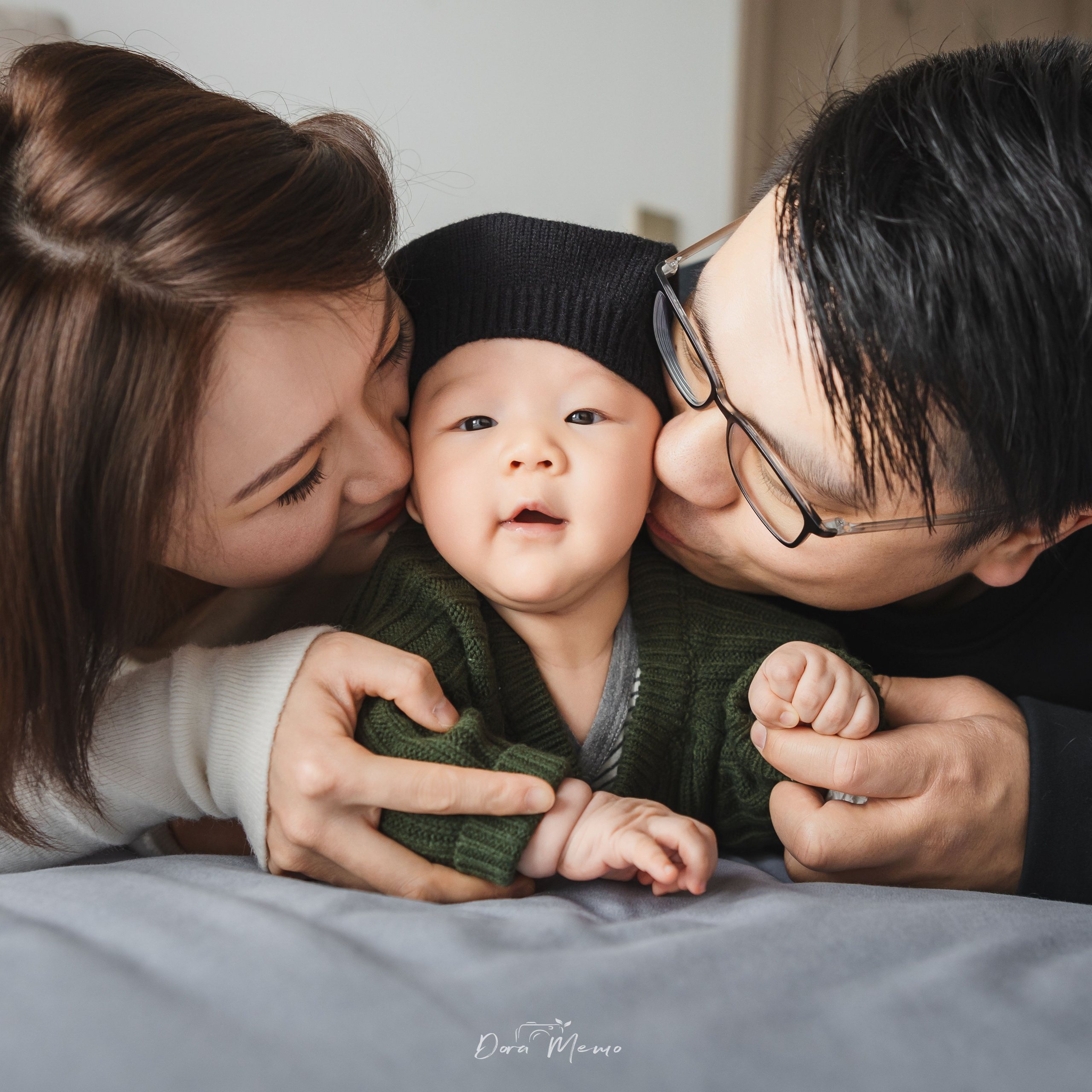 Parents kissing baby on cheeks, emotional family moment, Shanghai lifestyle newborn photography