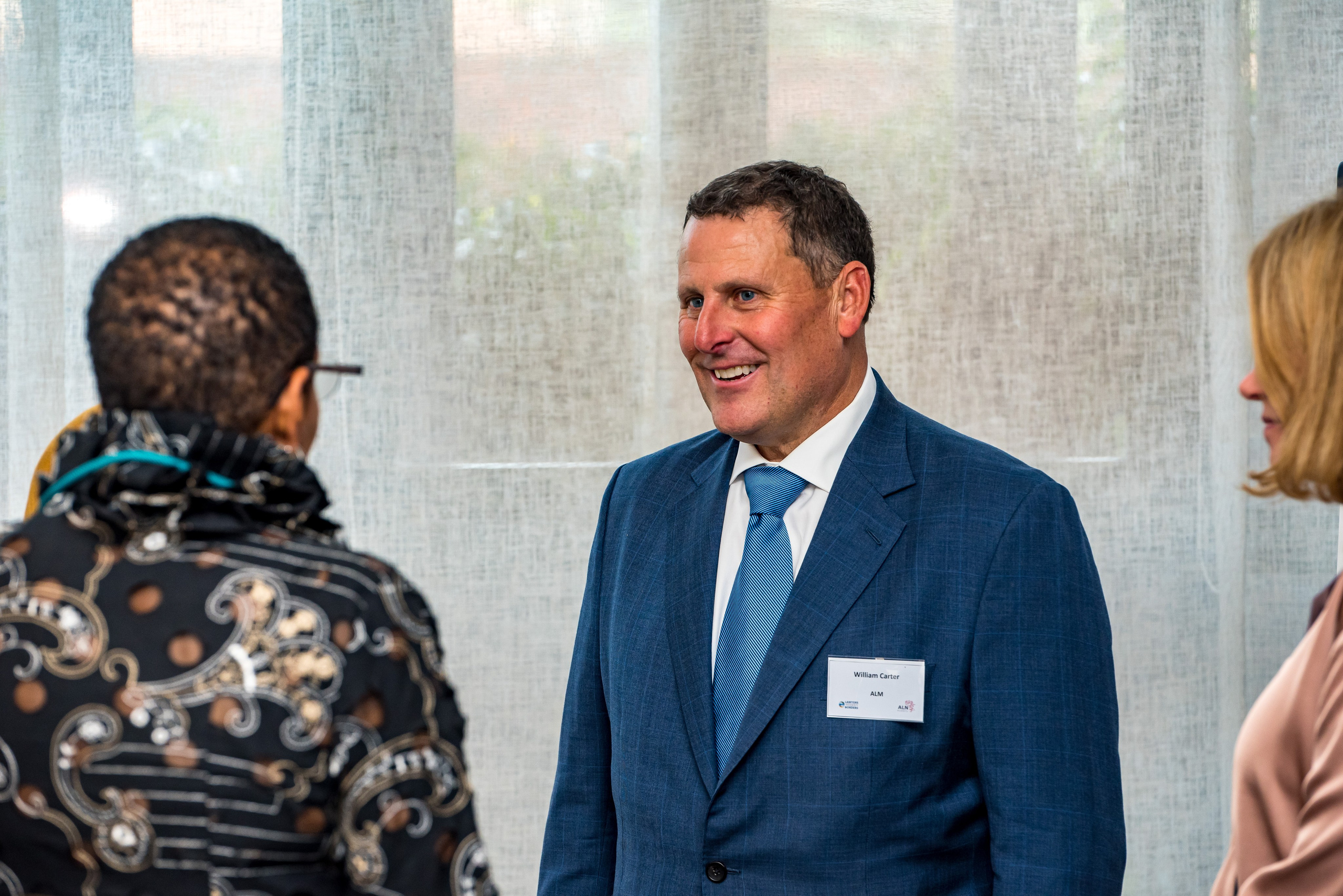 Candid portrait of smiling executive in conversation at a corporate function in Nairobi.