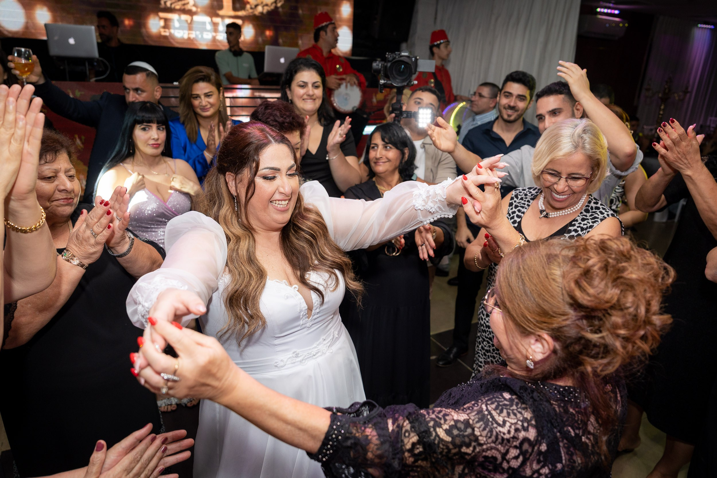 Ella dances with her mother and Matan during the reception.