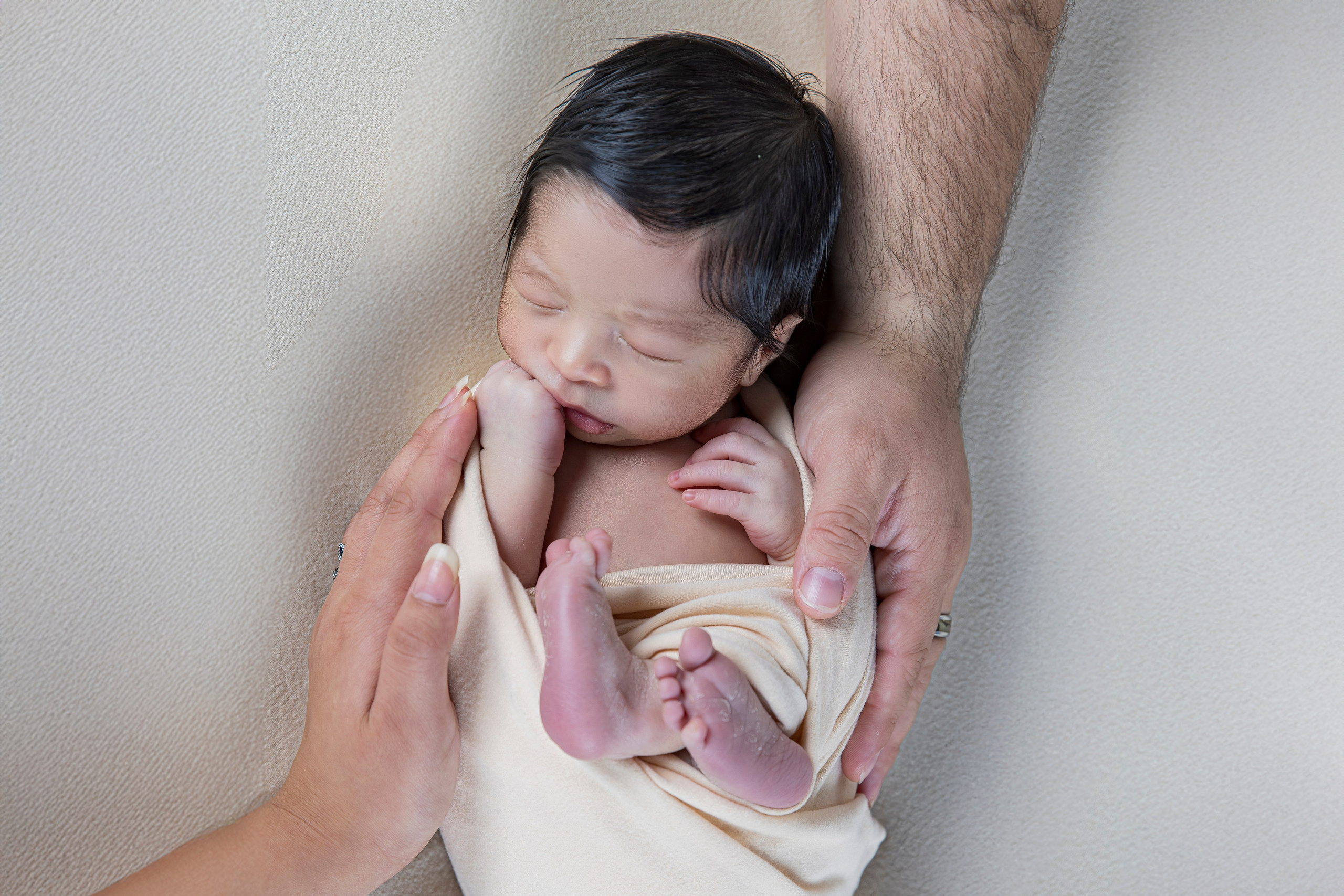 Primer retrato familiar con bebé recién nacido en brazos, fotografía de familia natural y emotiva en Torrejón de Ardoz.