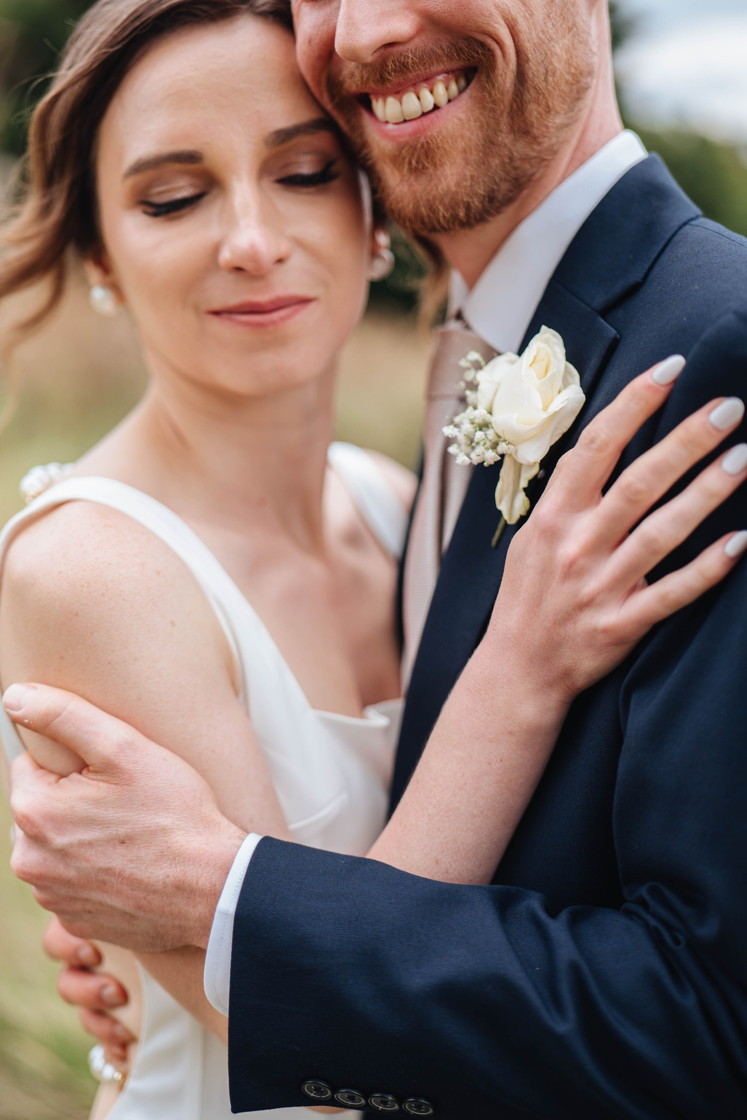 bride and groom hugging with their eyes closed