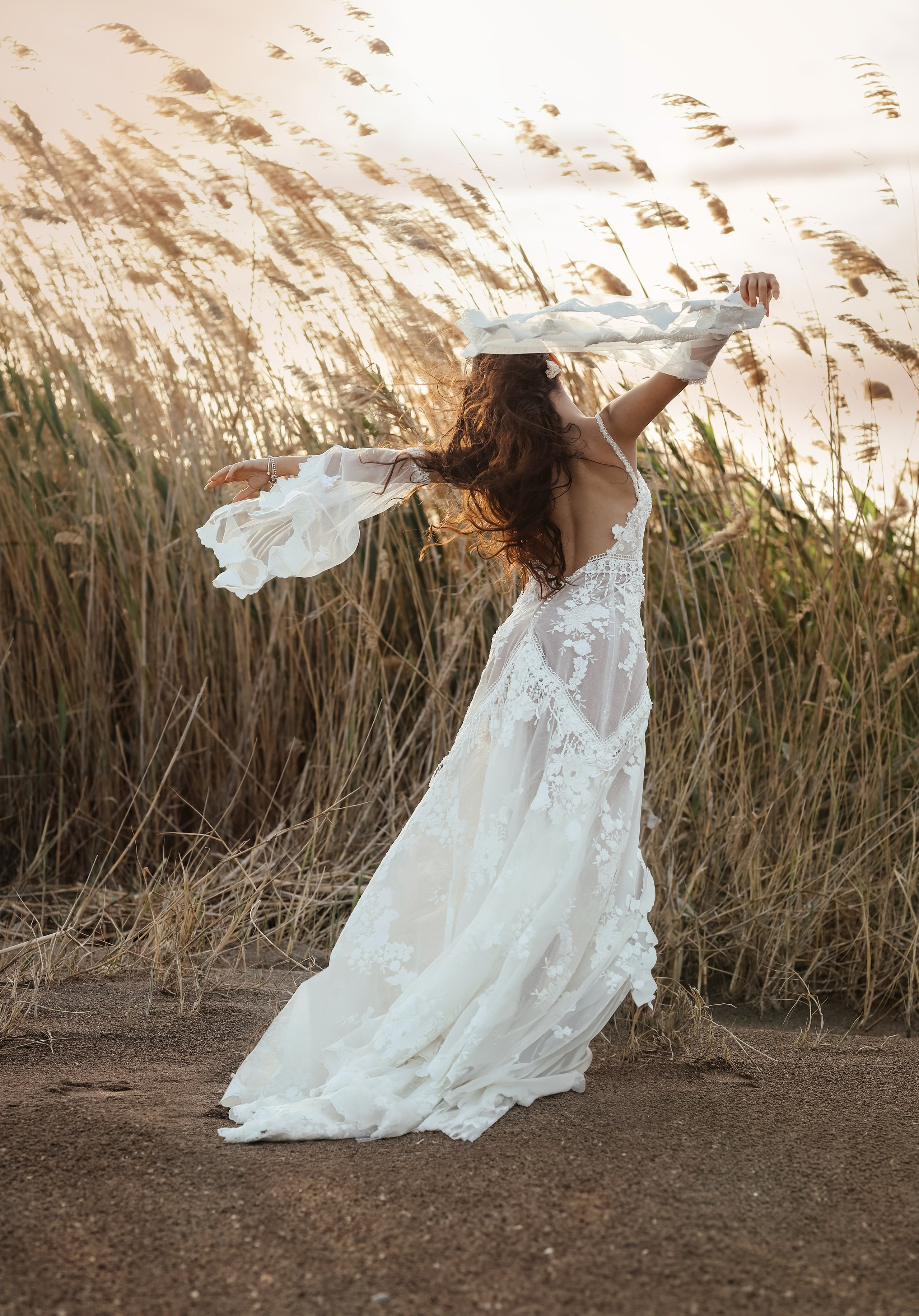 A portrait of girl in a wedding dress on a sunset background in reeds. Rhodes, Greece