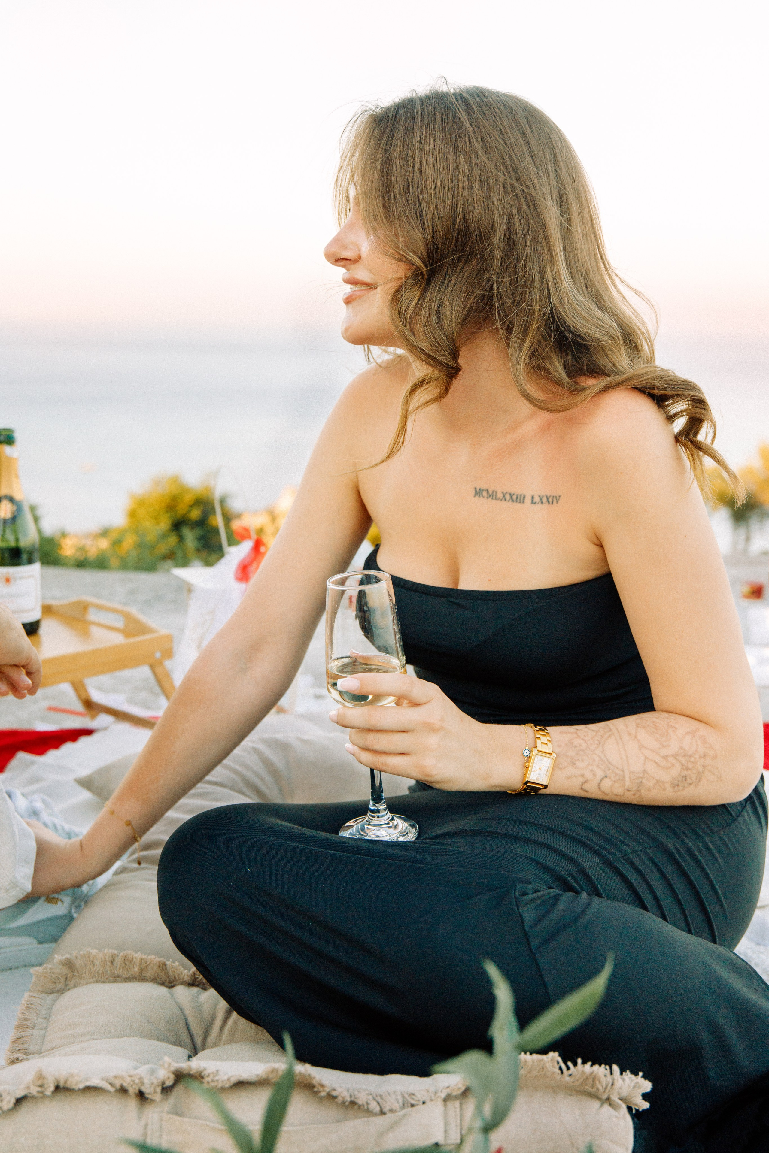 "Anstoßen auf die Liebe: Ein Paar genießt ein Glas Sekt nach dem Heiratsantrag auf dem Profitis Ilias, hoch über der Küste von Faliraki und dem azurblauen Mittelmeer."